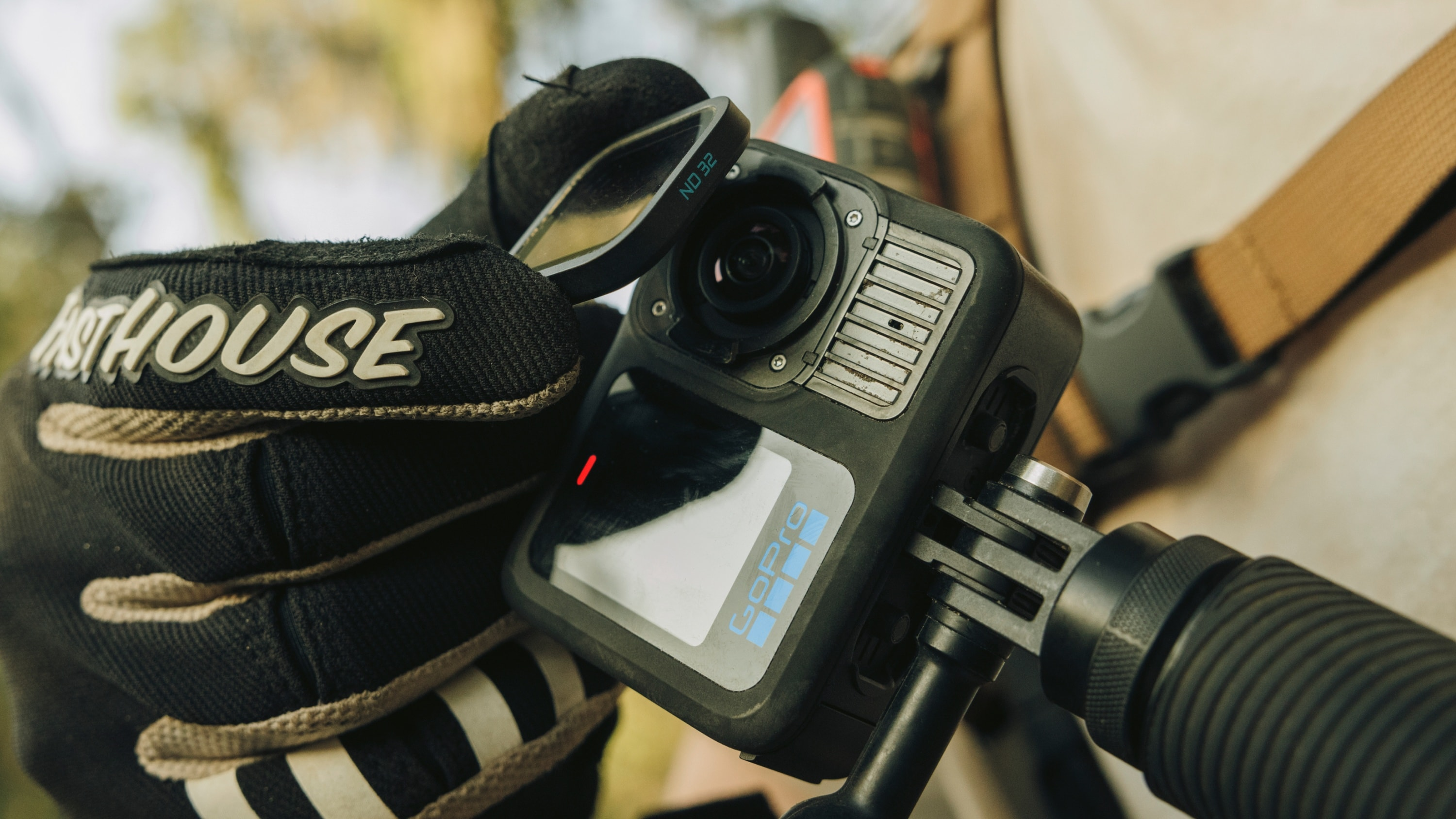 GoPro-Kamera an einem Fahrradlenker montiert. Eine Hand hält den ND 32-Linsenfilter.