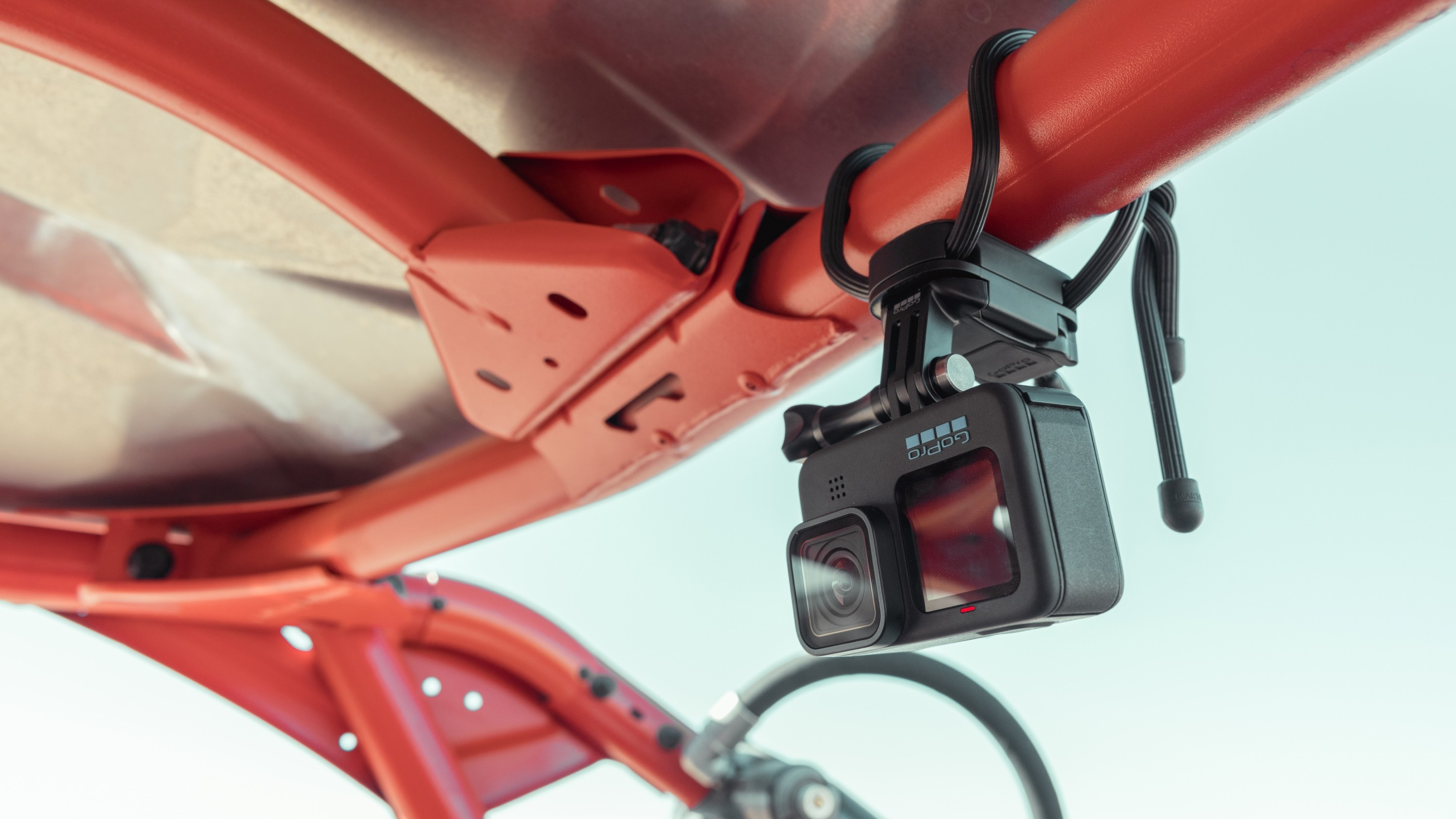 GoPro-Kamera an einem roten Fahrzeugrahmen befestigt, zum Himmel ausgerichtet.