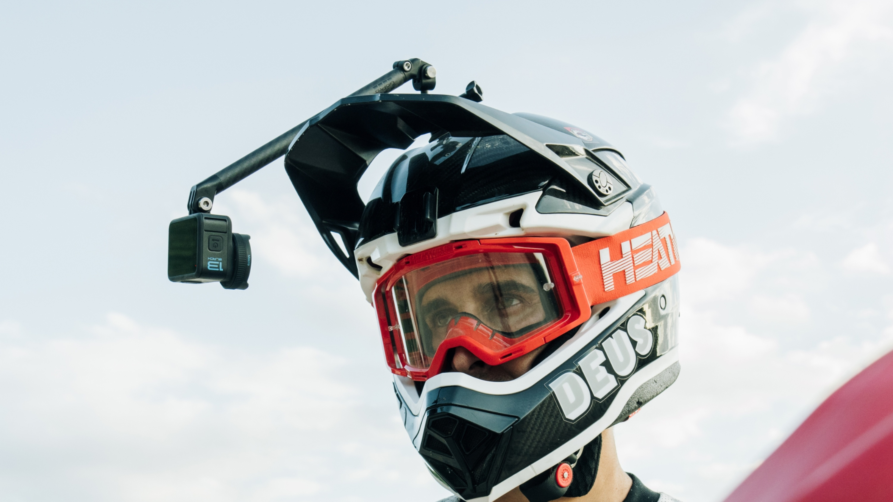 Eine Person mit Motorradhelm und befestigter GoPro, die in die Kamera schaut.