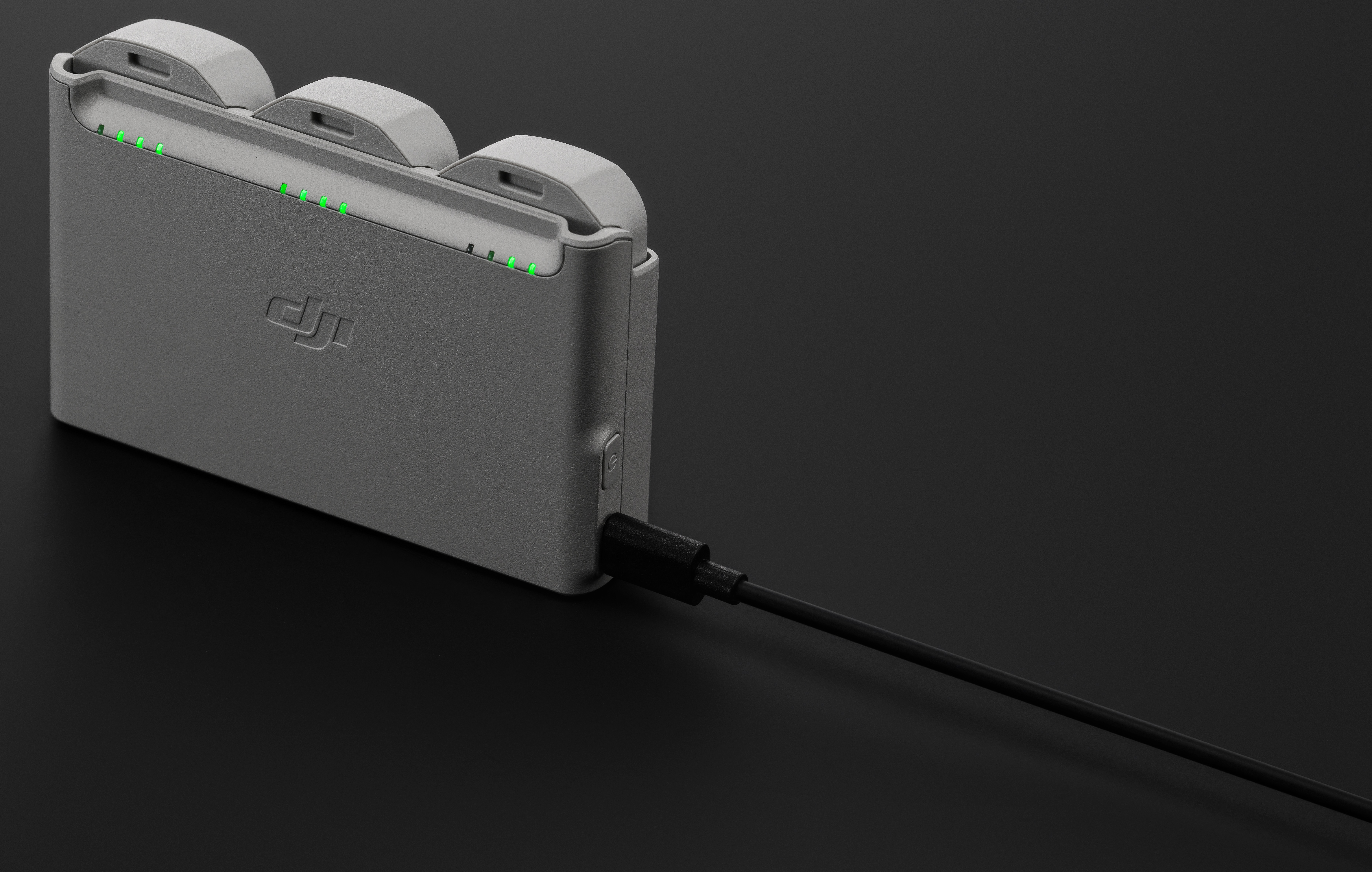 Biała stacja ładująca z czarnym kablem i szarym urządzeniem ładującym.