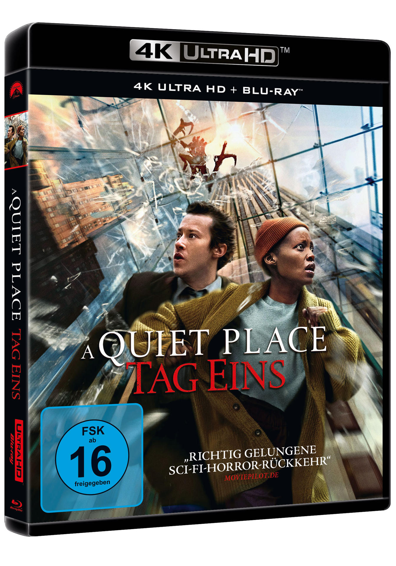 Filmcover für A Quiet Place: Day One. Zwei Personen blicken ängstlich nach oben. Gebäude stürzen im Hintergrund ein.