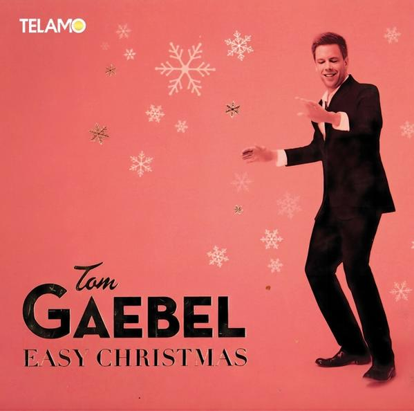 Albumcover mit Tom Gaebel auf rotem Hintergrund. Weihnachtsthema mit Schneeflocken und Text.