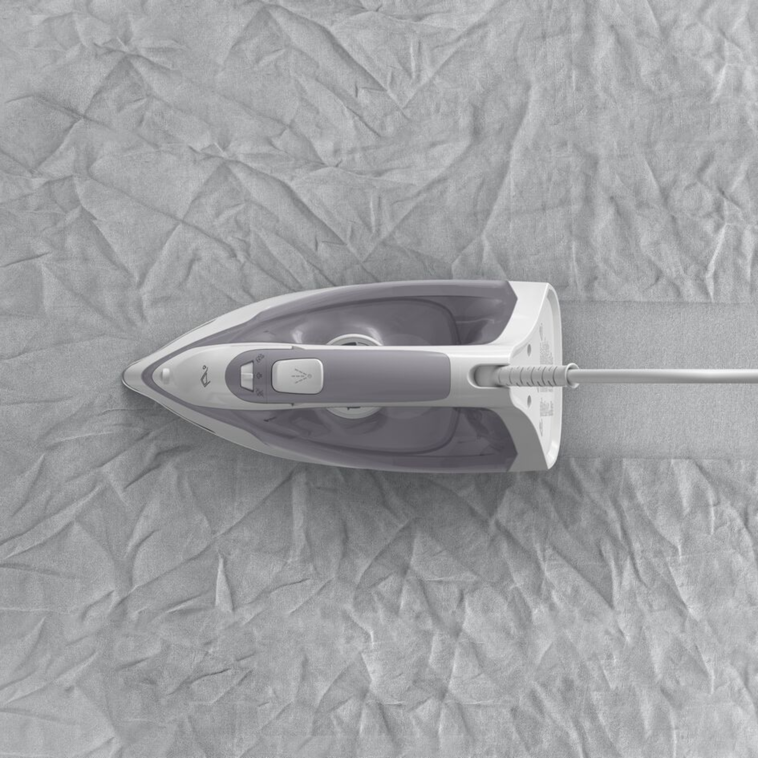 Top view of a white and gray iron on a gray fabric.