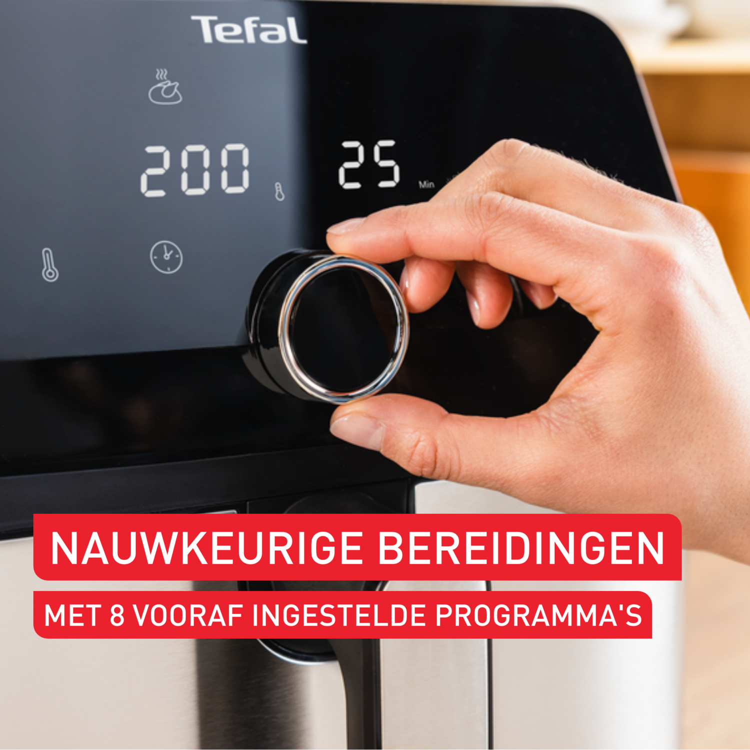 A hand turns the dial on a Tefal air fryer with a digital display.