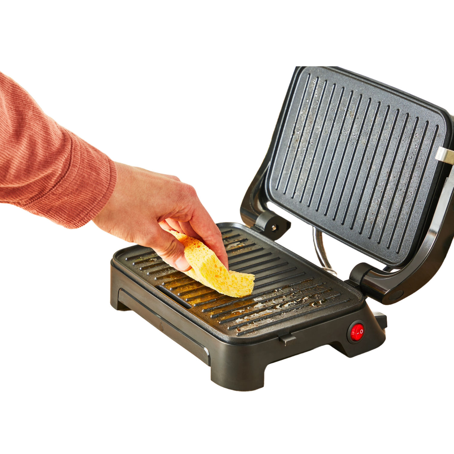 Een hand die brood op een hete grill legt.