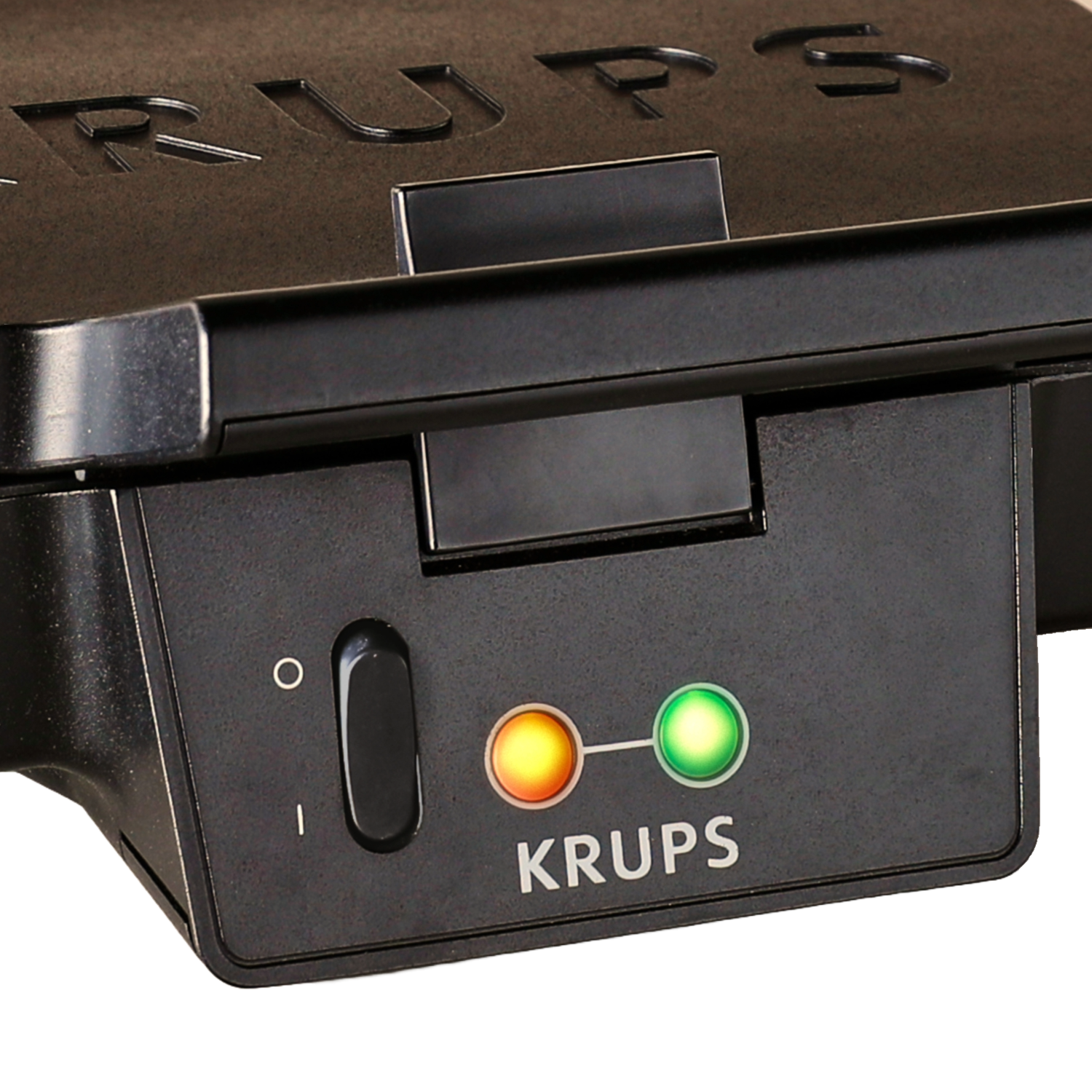 Waffle iron, black. Power button and indicator lights. Krups logo is visible. Close-up view.