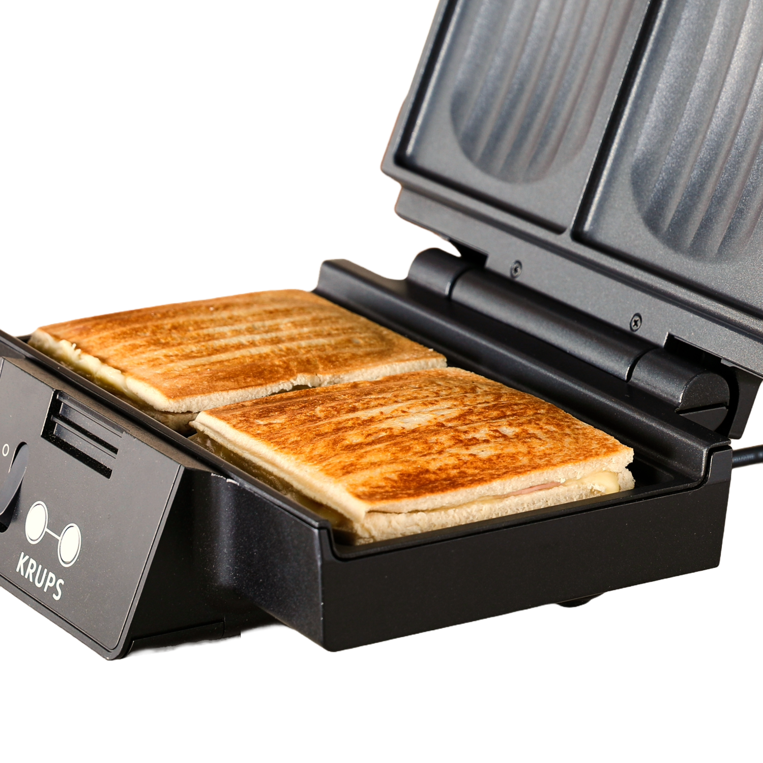 A black sandwich maker with two toasted sandwiches inside. The lid is open. Black background.