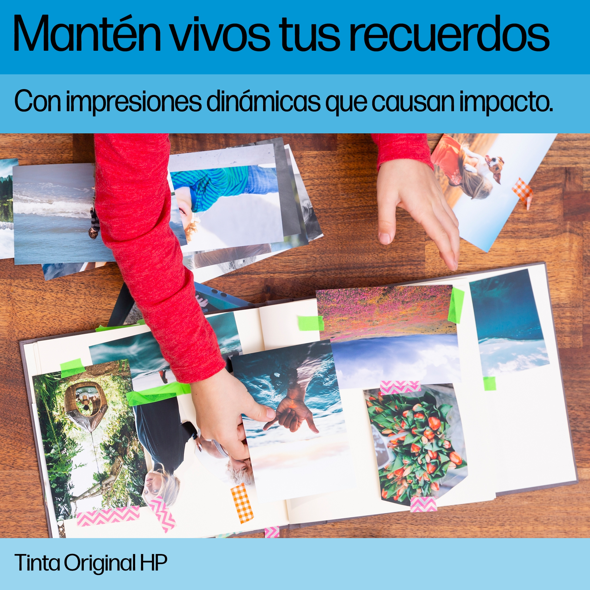 Manos ordenando fotos en un álbum de recortes, algunas con cinta de colores, en una mesa de madera.