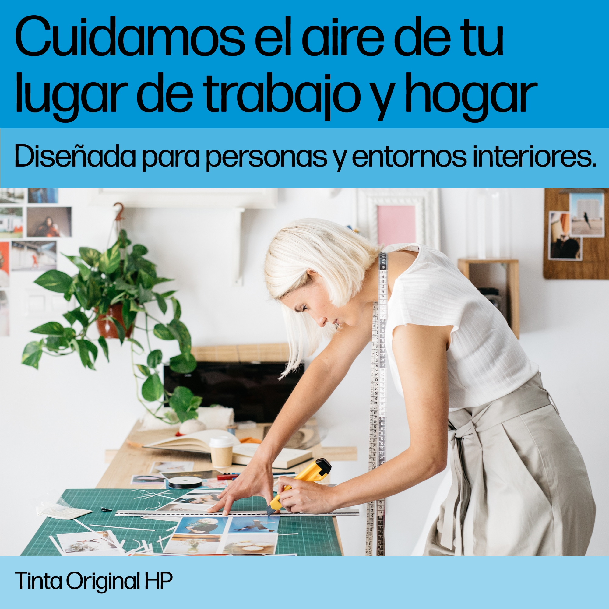 Una mujer trabajando en un escritorio, cortando fotos. Texto arriba: "Cuidamos el aire de tu lugar de trabajo."