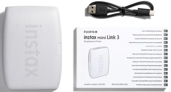 Imprimante blanche Instax mini Link 3, câble USB et manuel sur fond blanc. La boîte et l'imprimante affichent le logo Instax.