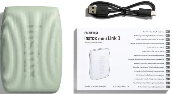 Une imprimante Instax mini Link 3 vert menthe, un câble USB et un livret sur fond blanc.