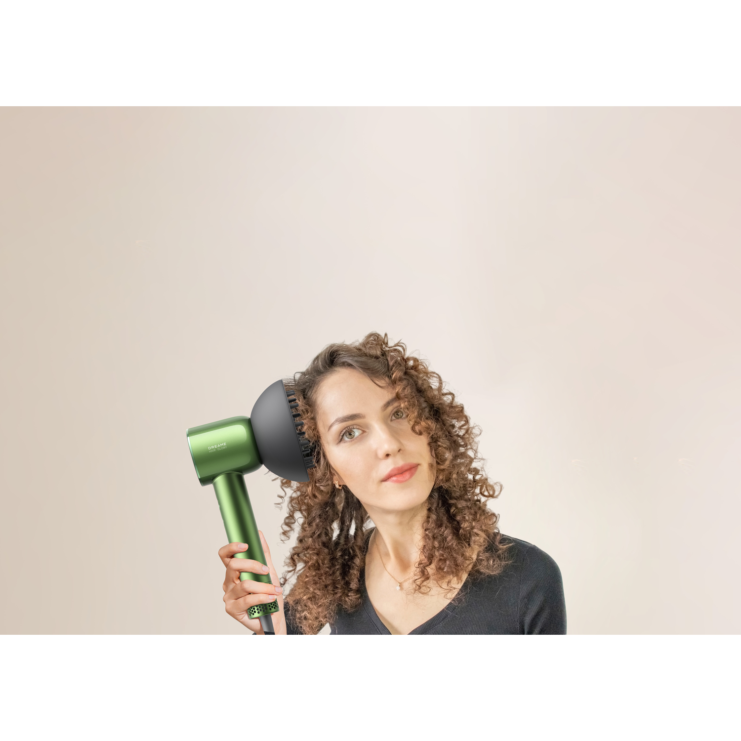 A woman drying her curly hair with a green hair dryer.