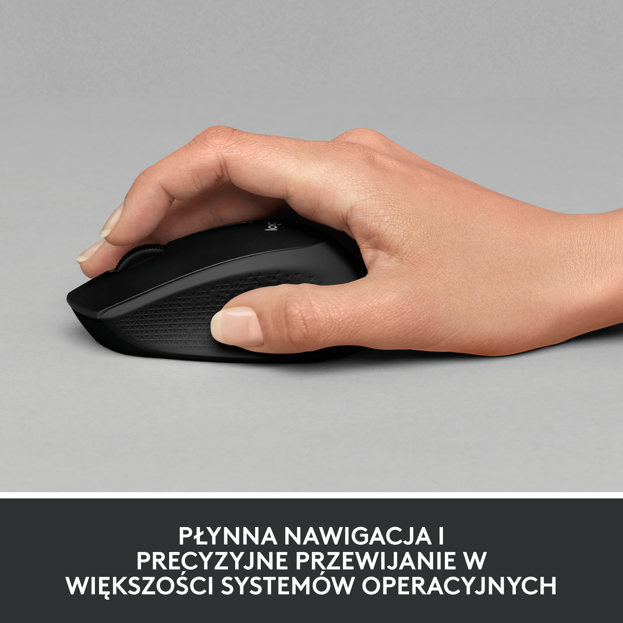 Dłoń trzymająca czarną mysz Logitech na szarej powierzchni z tekstem poniżej.