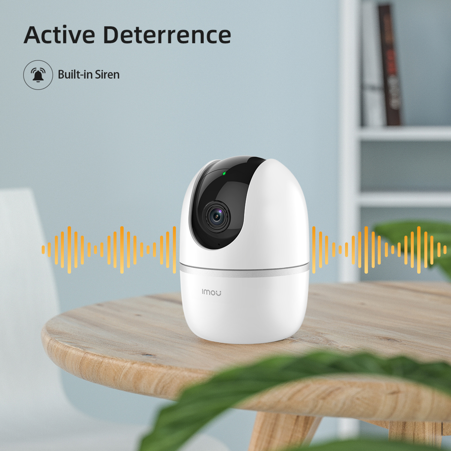 White security camera on a wooden table. Text says 'Active Deterrence' and 'Built-in Siren'.