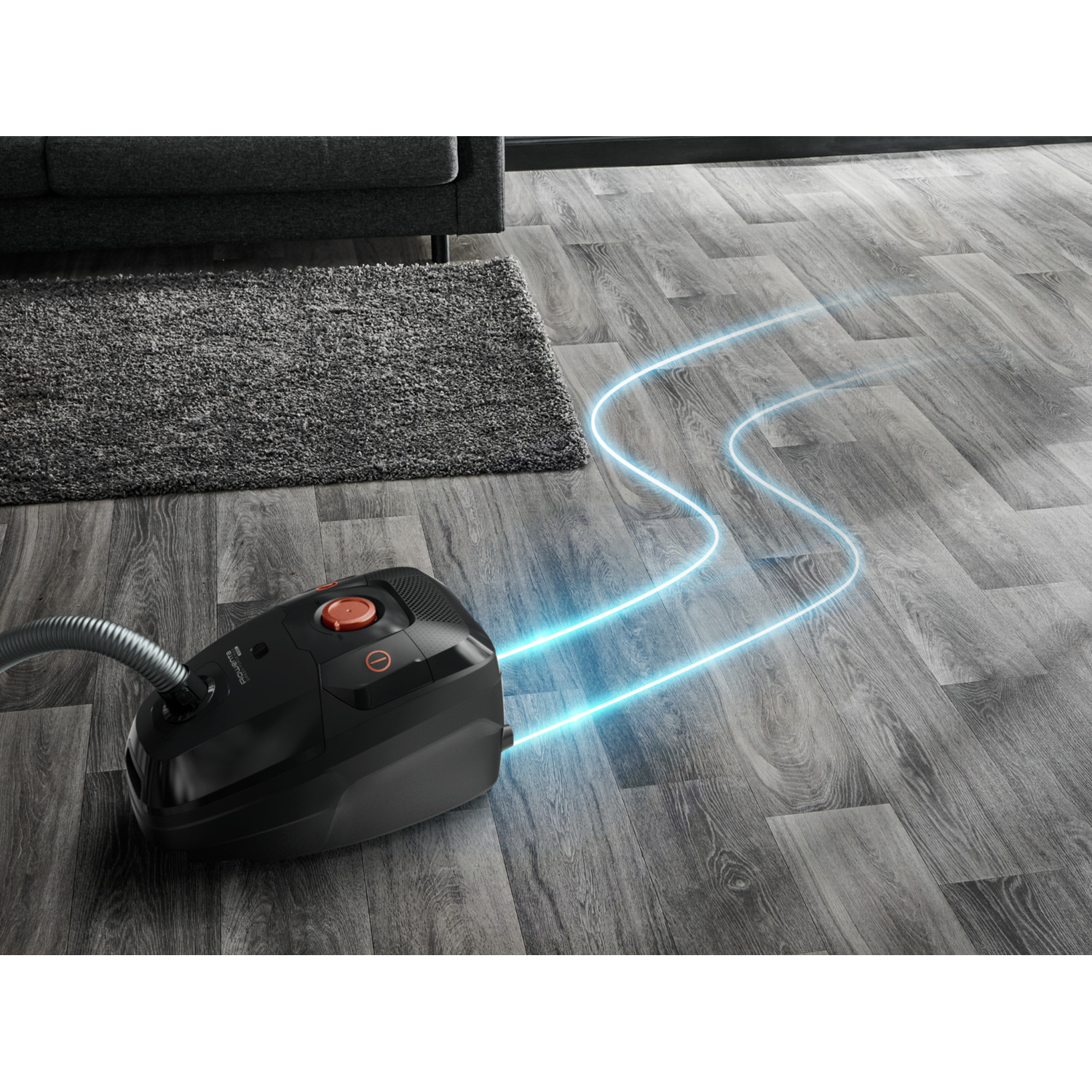 Black vacuum cleaner on a wooden floor with blue energy lines.