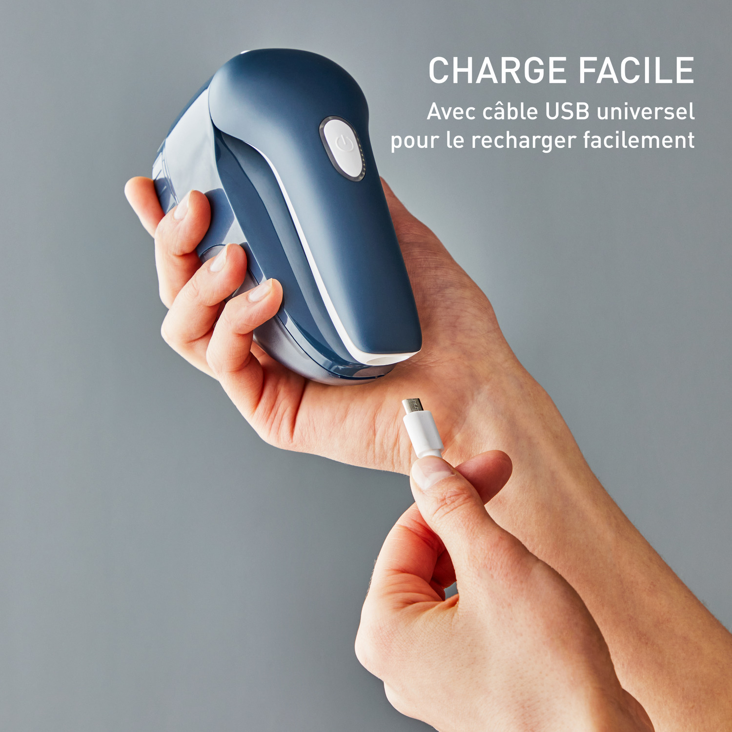 Mains tenant un rasoir à tissu bleu et blanc, avec un câble USB.