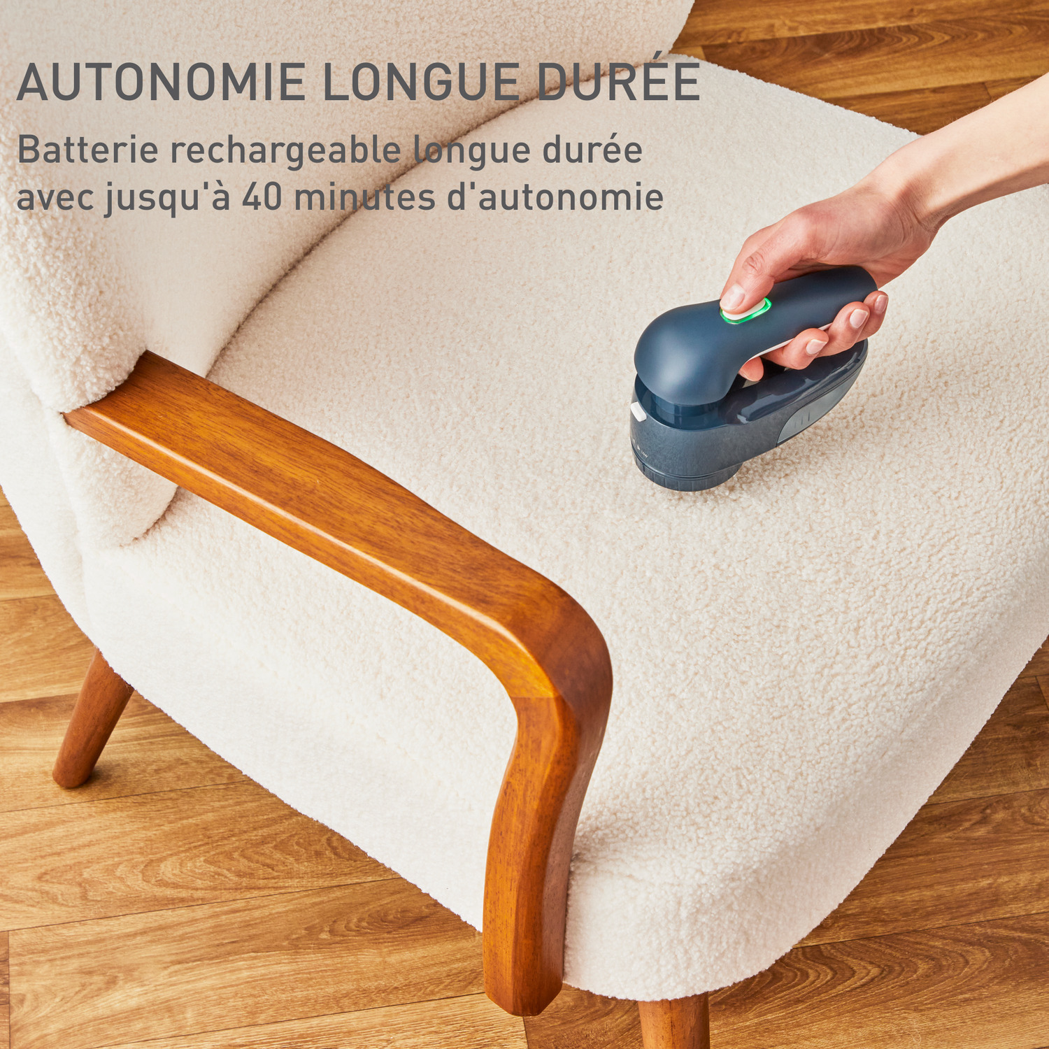 Une main utilise un rasoir à tissu sans fil sur une chaise blanche. Le texte dit longue durée de vie de la batterie, jusqu'à 40 minutes.