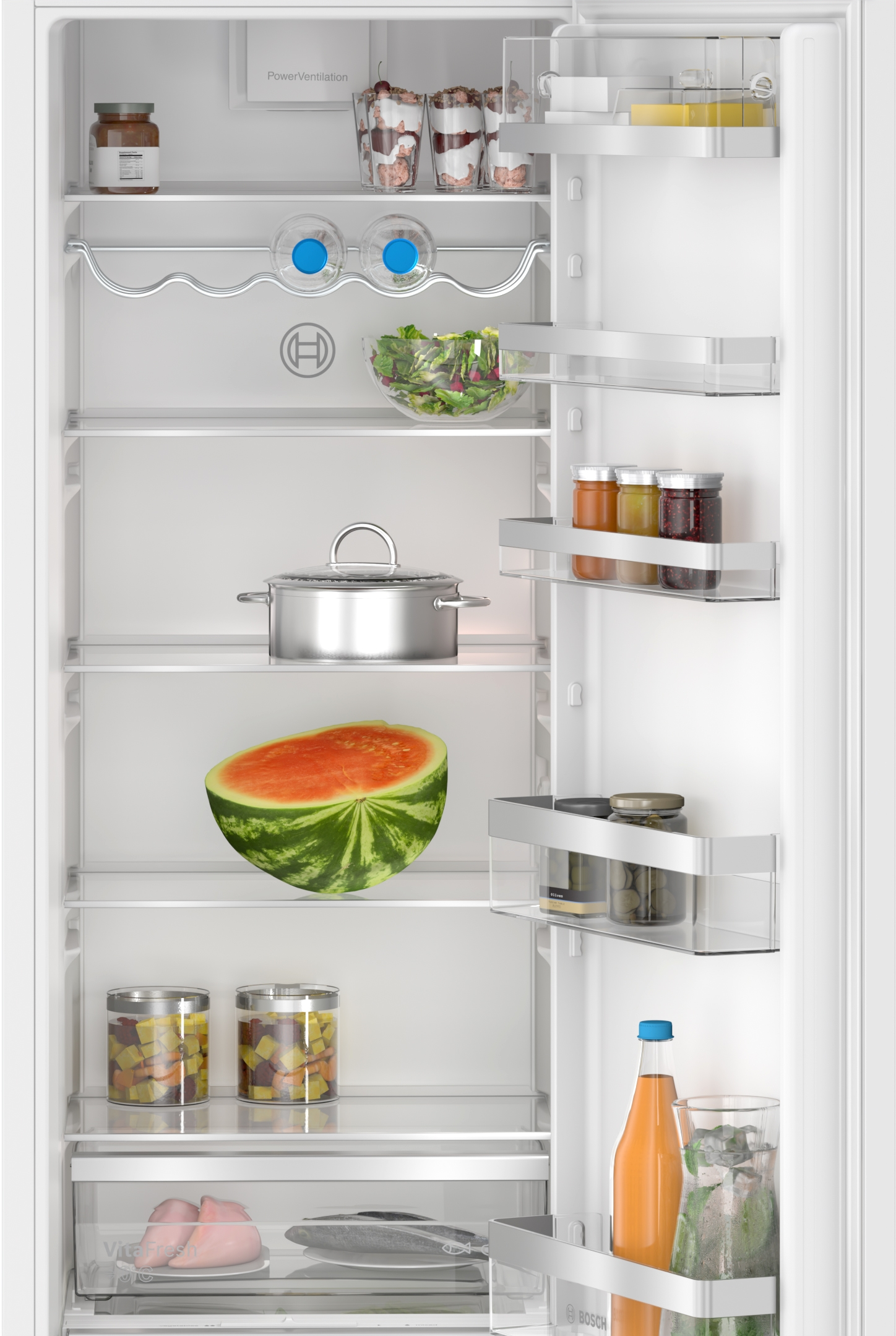 Innenraum eines Kühlschranks, Regale sind mit Lebensmitteln gefüllt: Gläser, eine Wassermelone, Behälter und frische Produkte.