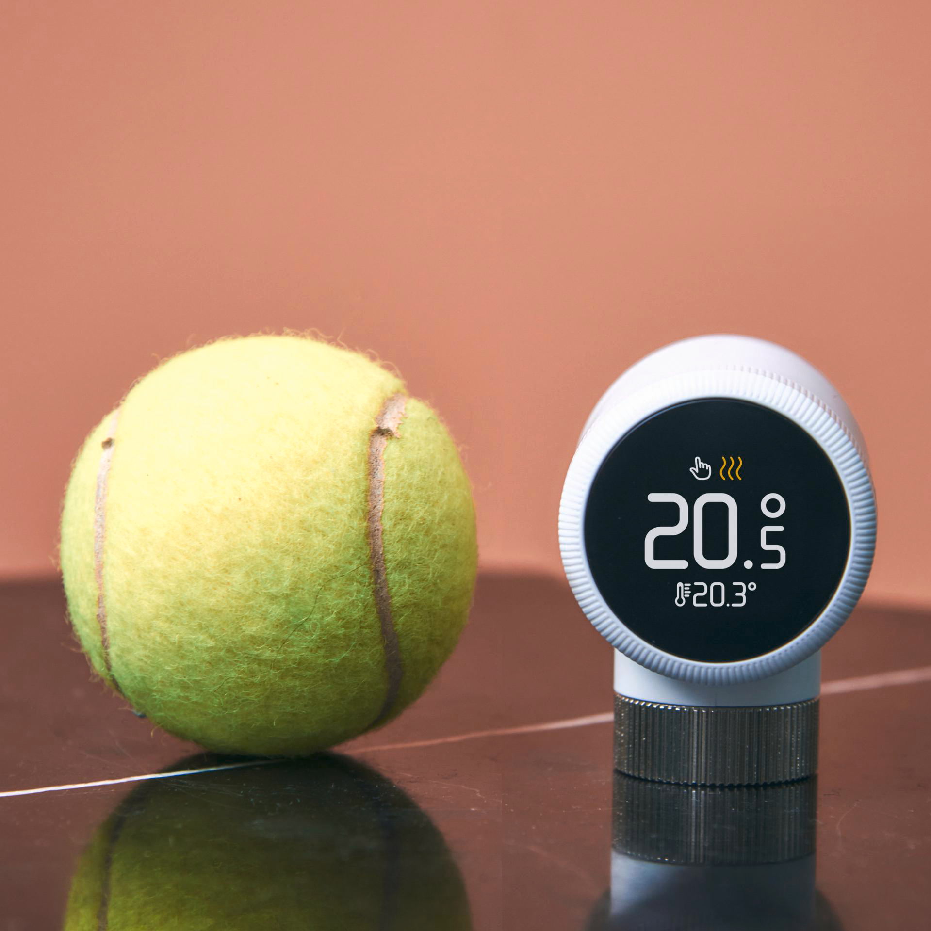 Tennisball neben Thermostat, 20,5 Grad Celsius.