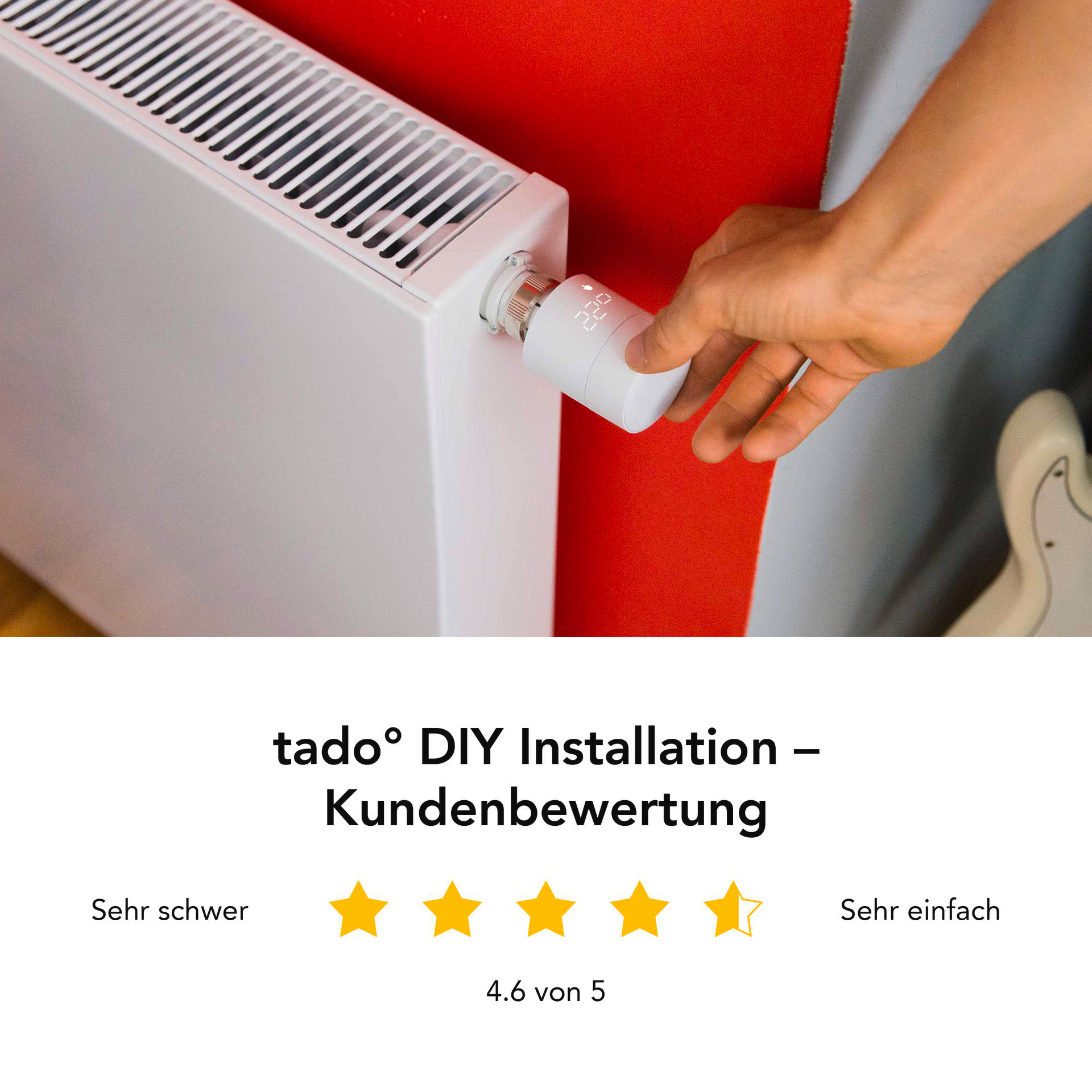Eine Hand dreht den Thermostat eines weißen Heizkörpers vor einer roten Wand.