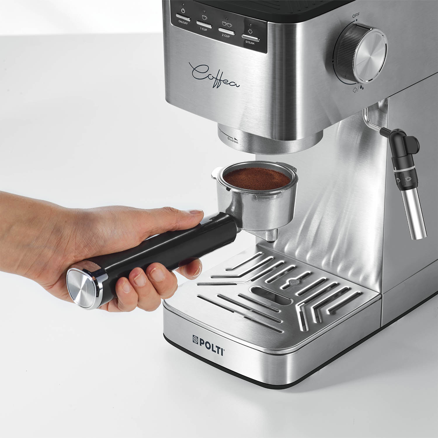 Una mano che inserisce un portafiltro in una macchina per caffè espresso in acciaio inox. Il caffè macinato è nel filtro.
