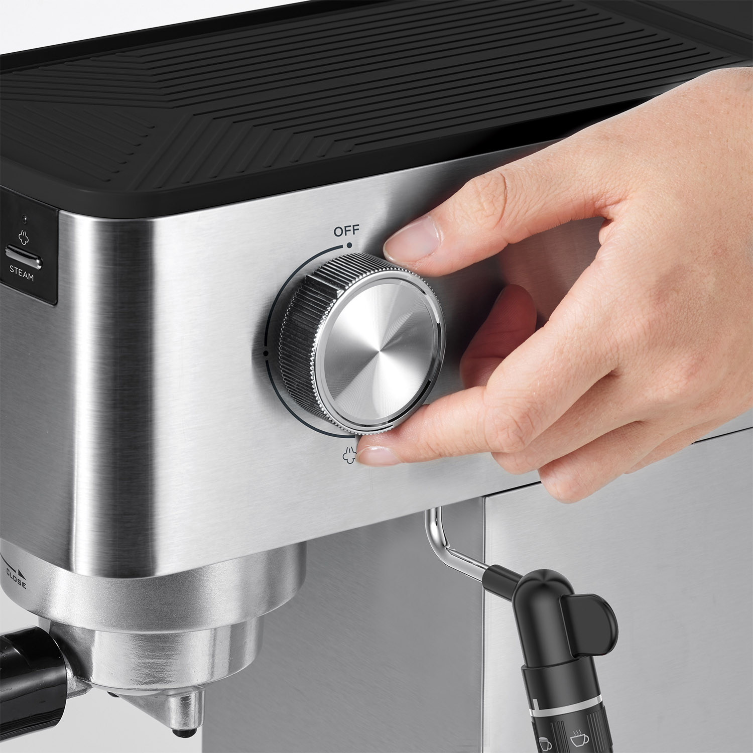 Mano che gira una manopola argentata su una macchina per caffè espresso argentata e nera.
