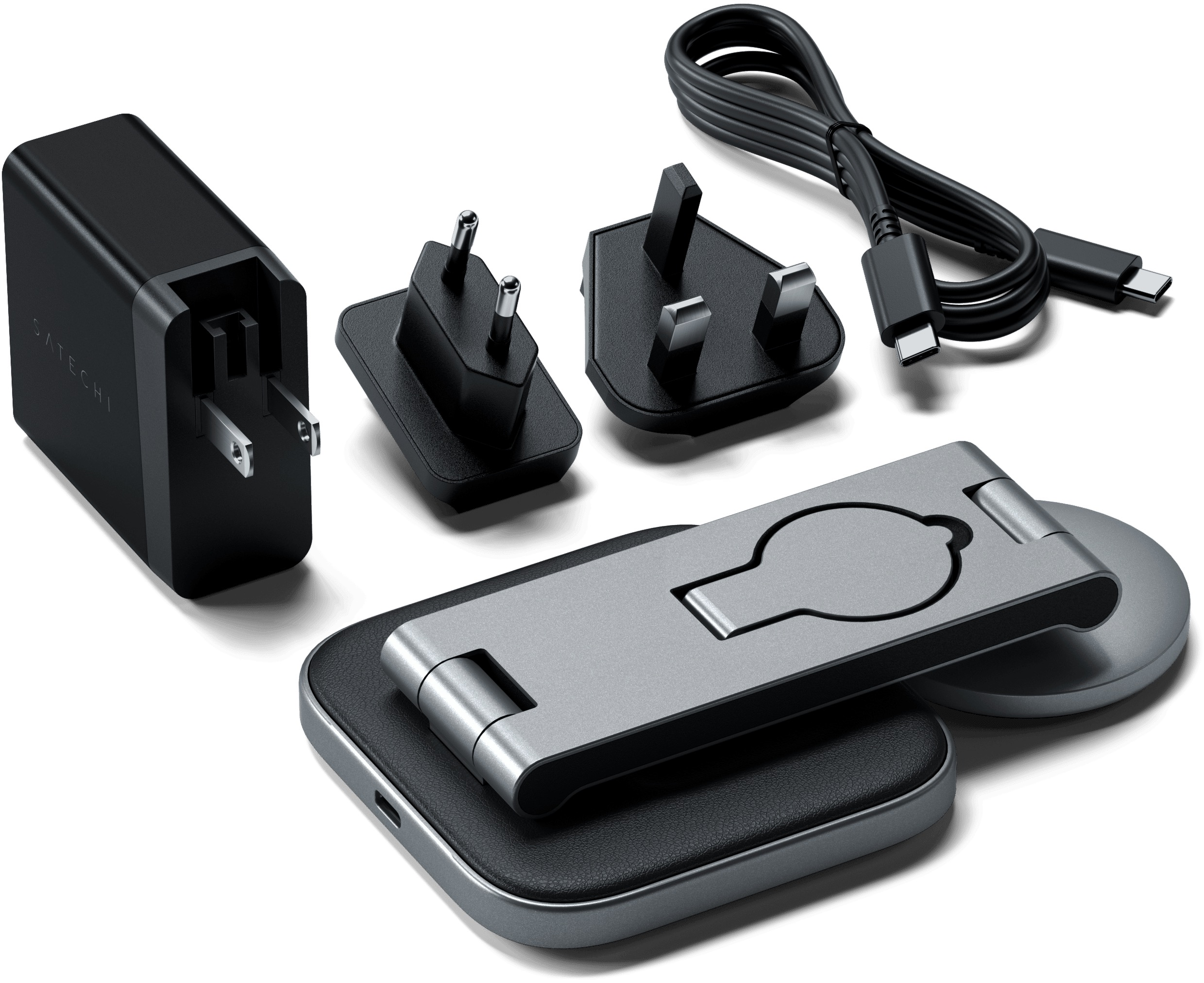 Un chargeur noir et diverses prises, un support pliable argenté et un socle de chargement noir, sur une surface blanche.