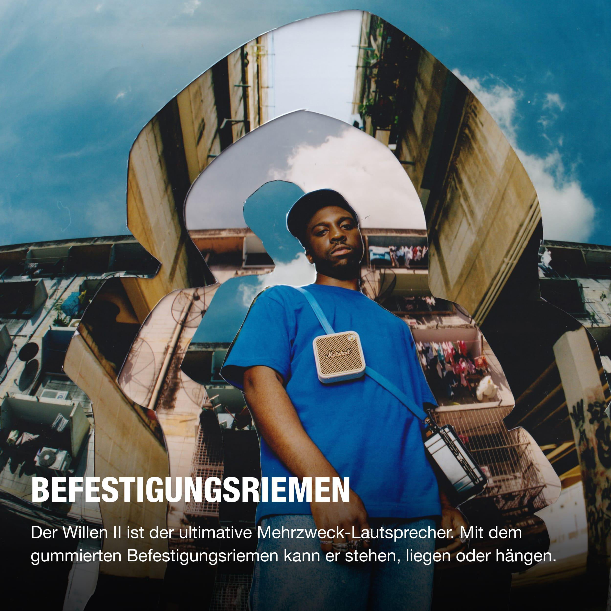 Ein Mann mit blauem Hemd und Marshall-Lautsprecher vor Gebäuden.