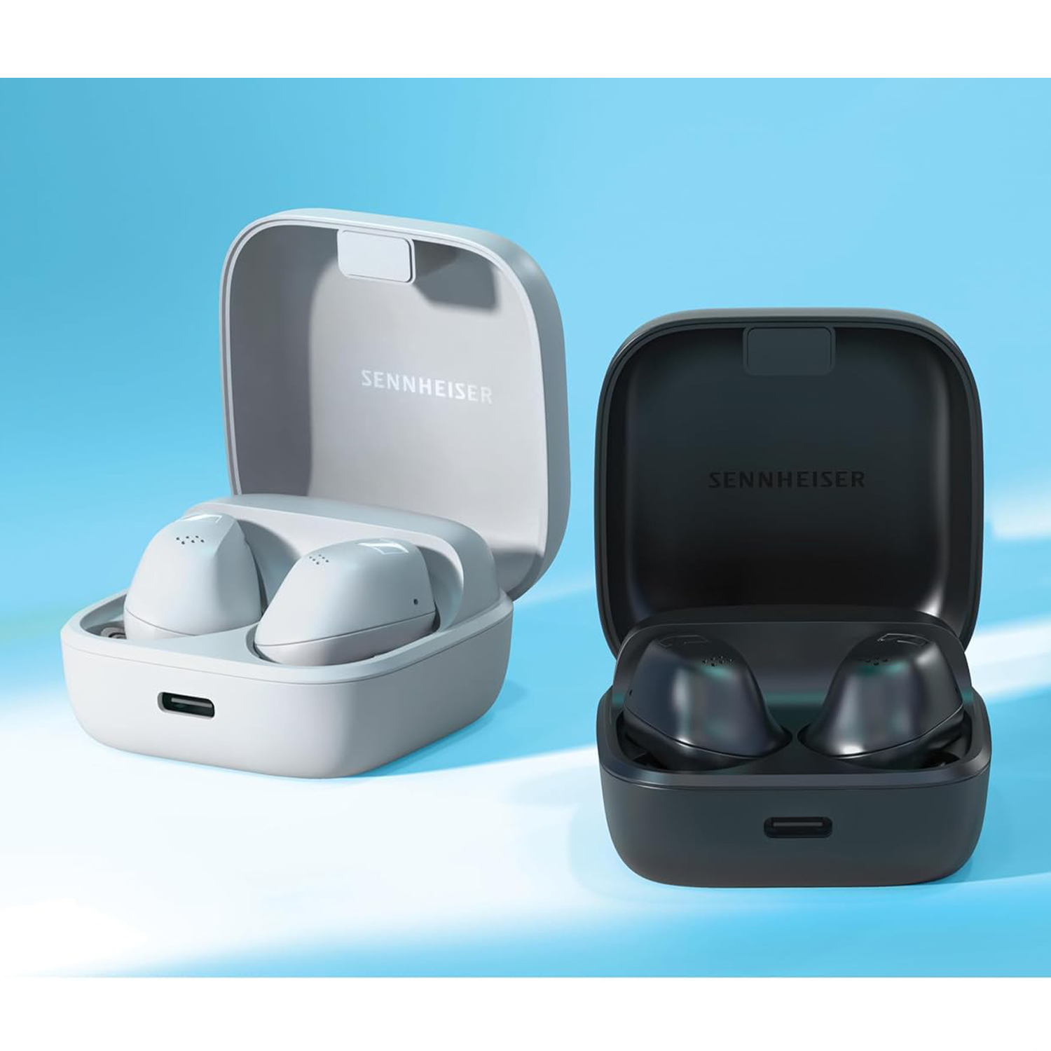 Due paia di auricolari wireless nelle loro custodie, uno grigio chiaro, uno nero.