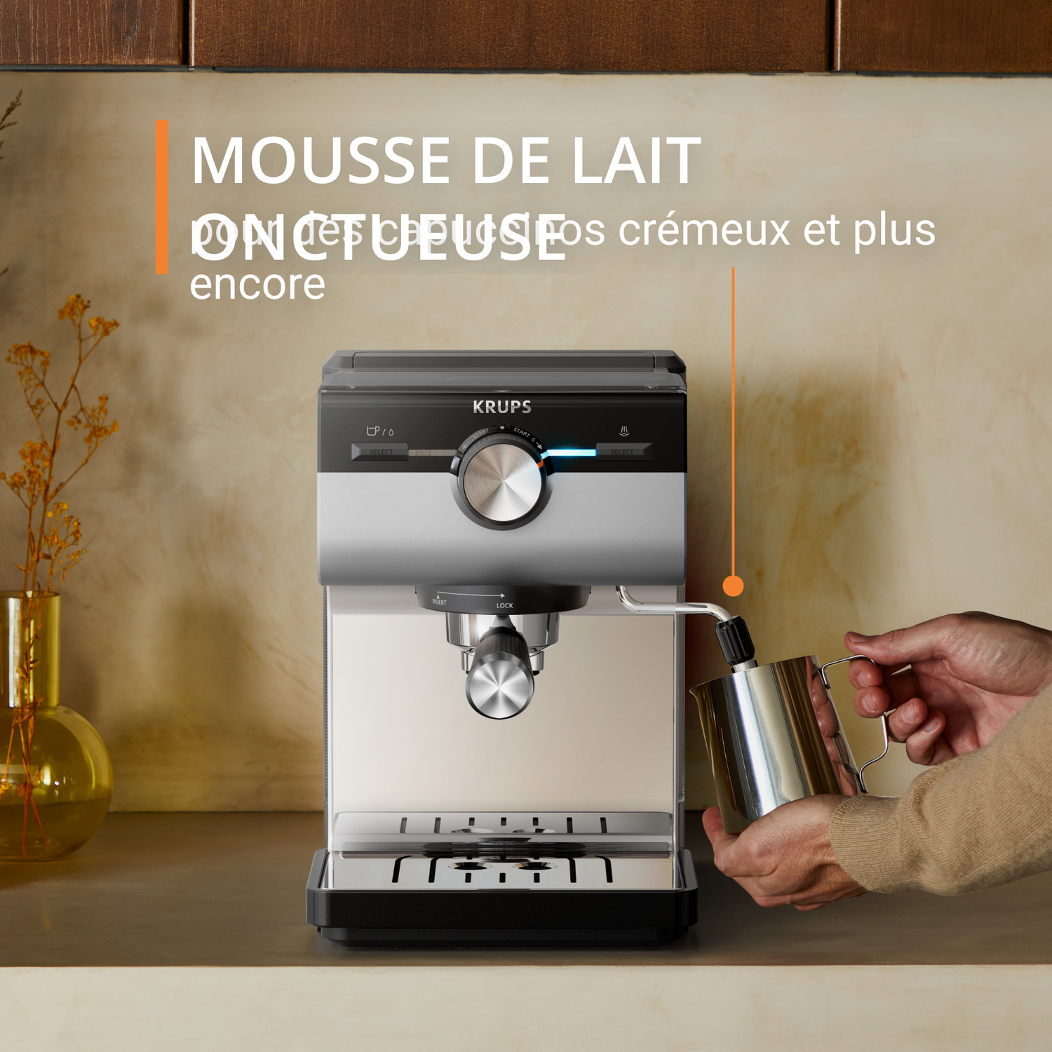Machine à café noire et argentée avec tasse en verre, fond blanc.