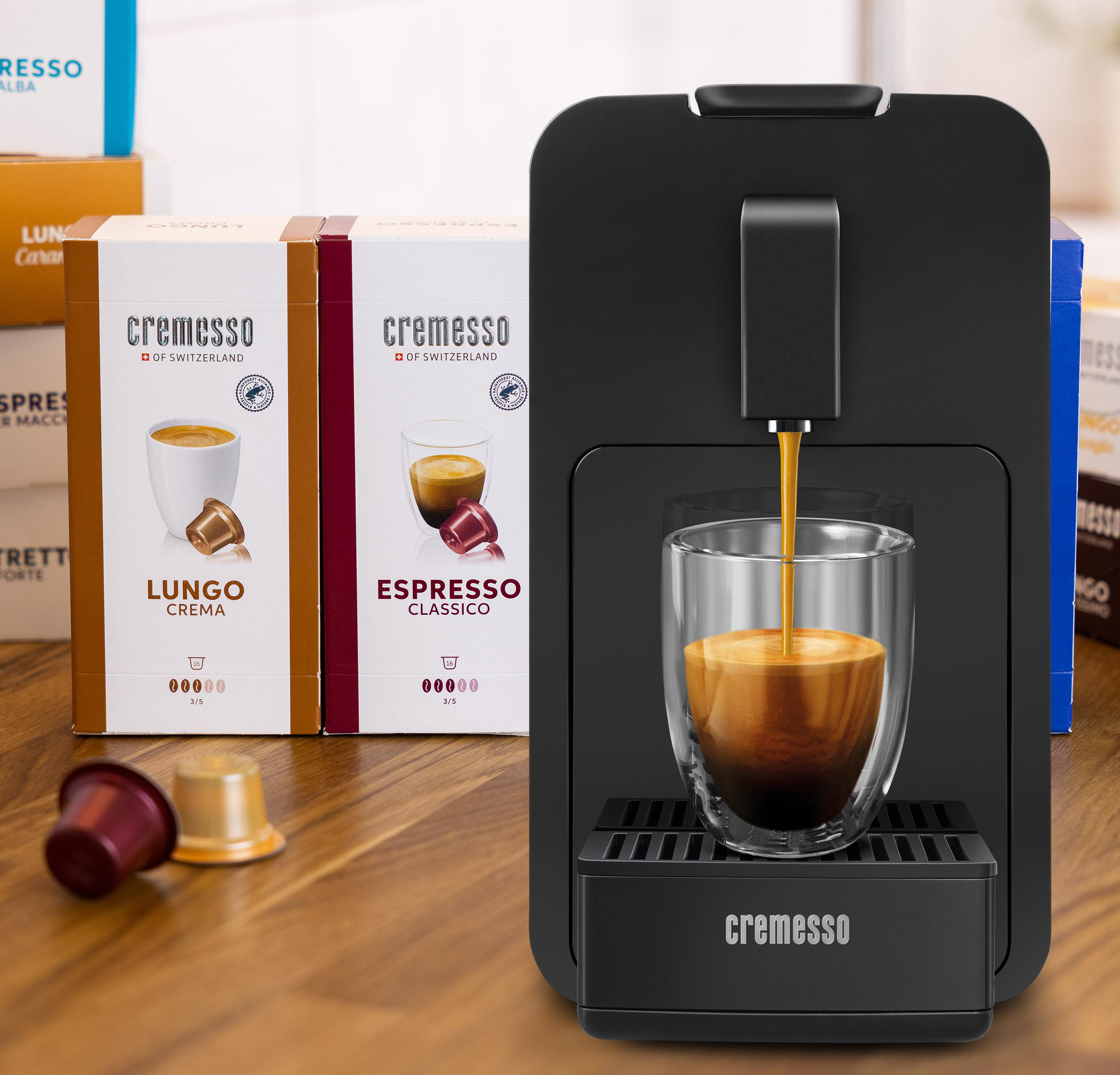 Espressomaschine mit einem Glas Kaffee und Kapseln.