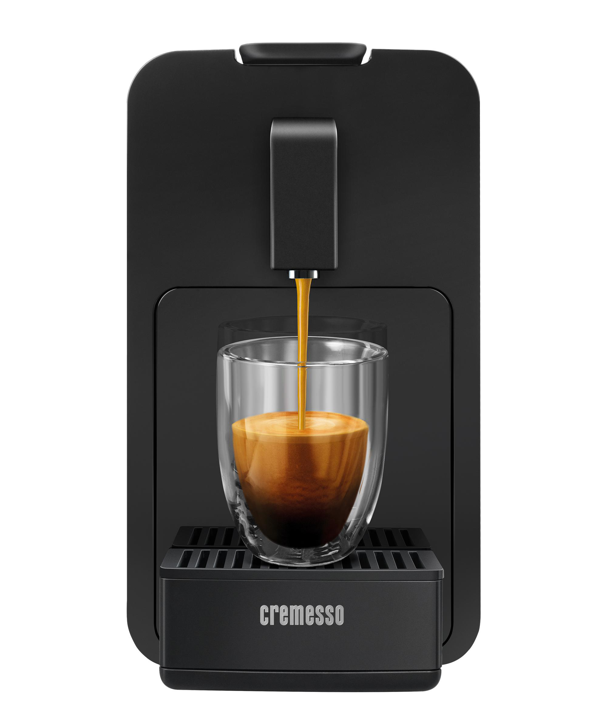 Schwarze Cremesso Kaffeemaschine, Kaffee fließt in ein Glas. Die Maschine steht auf weißem Grund.