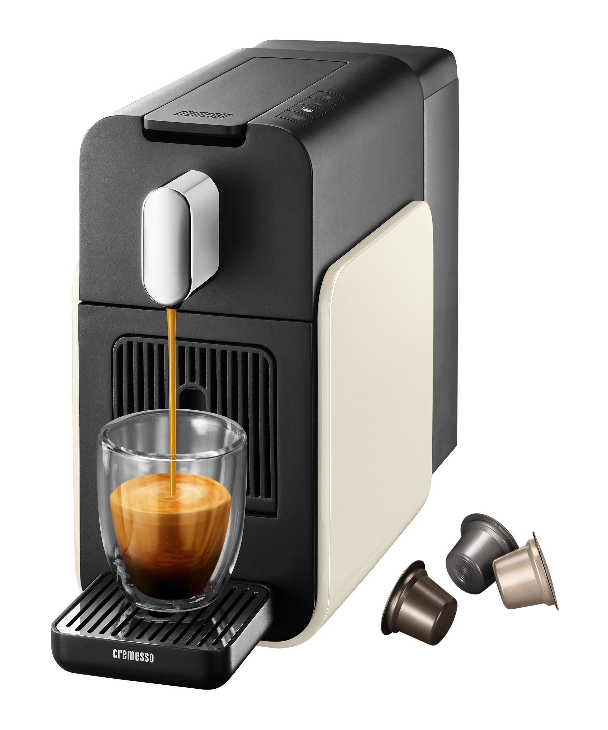 Espressomaschine füllt Tasse. Kaffeepads sichtbar. Maschine schwarz und beige. Kaffee gießt in Glas.