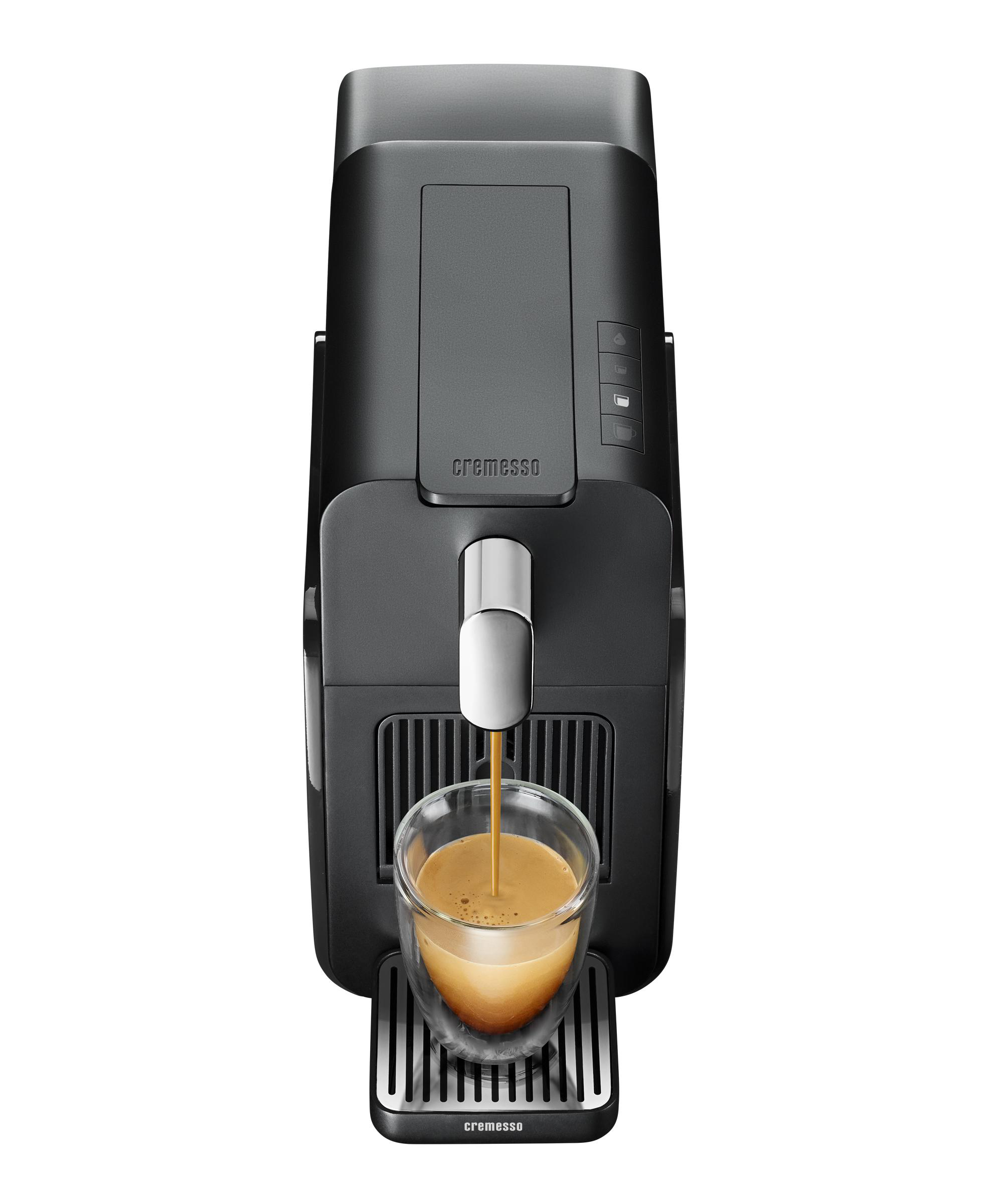 Eine schwarze Kaffeemaschine mit einer Glas Tasse, die sich mit Kaffee füllt, auf weißem Hintergrund.