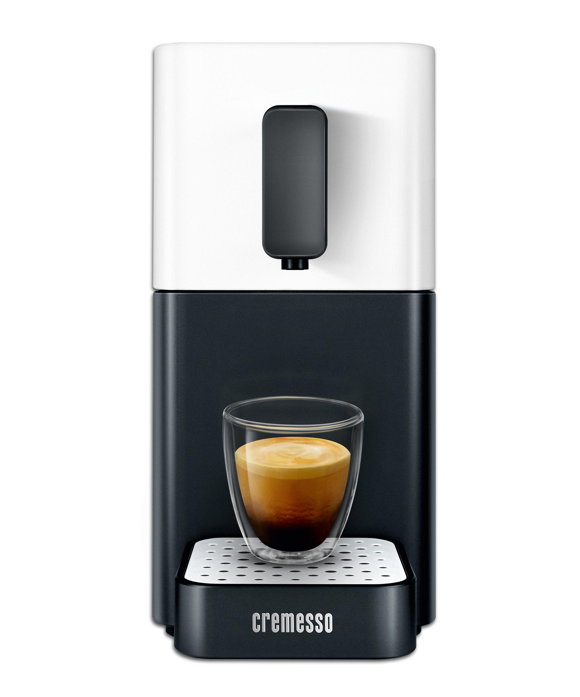 Schwarz-weiße Espressomaschine mit einem Glas Kaffee.
