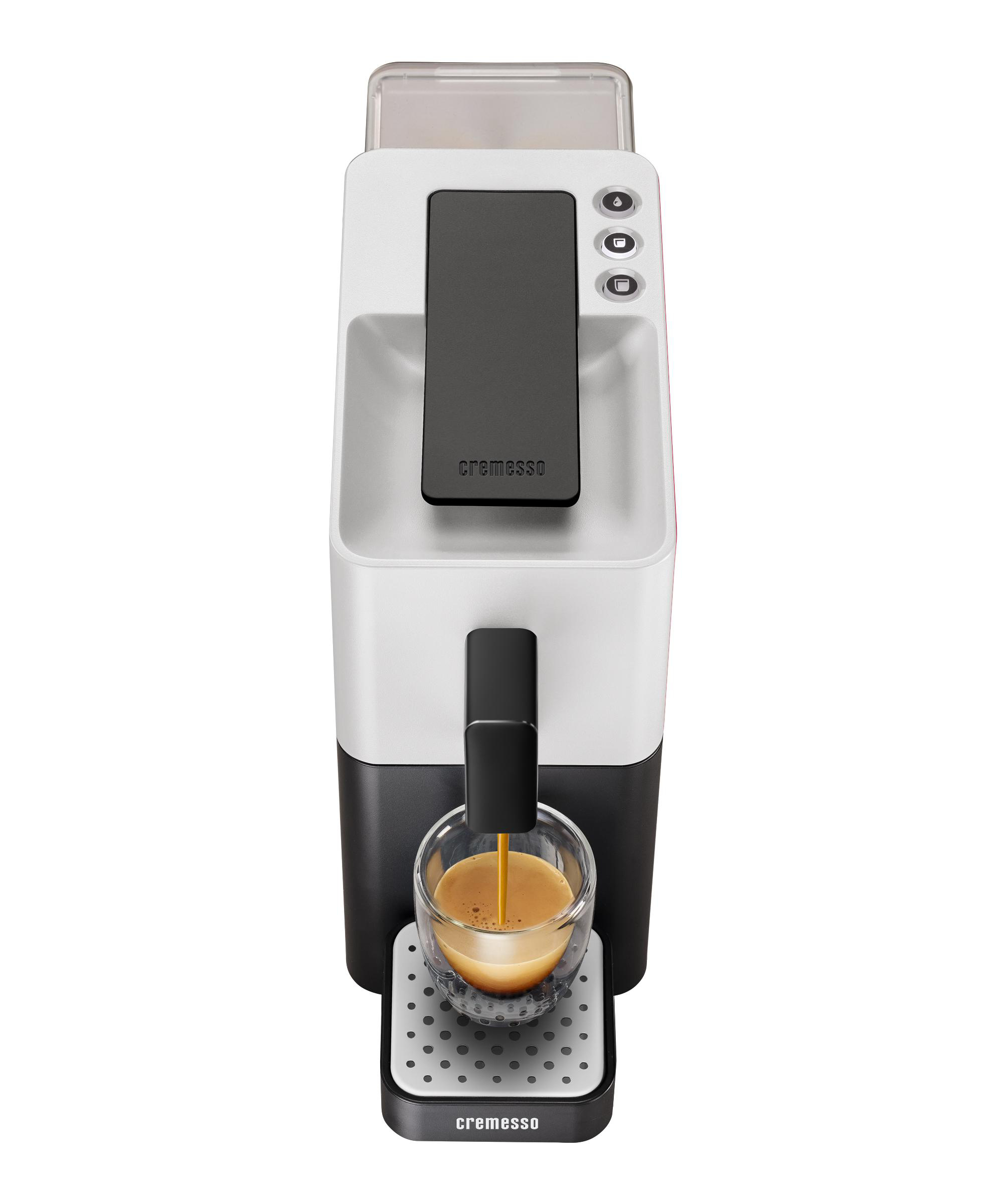 Eine weiß-schwarze Cremesso-Kaffeemaschine mit einem Glas Kaffee unter dem Auslauf.