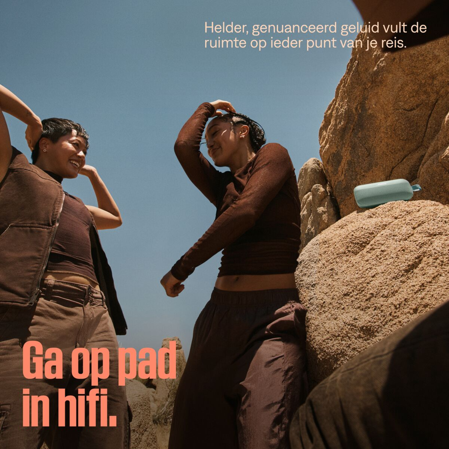 Two people posing on rocks, with a blue speaker. Text: Go on the road in hifi.