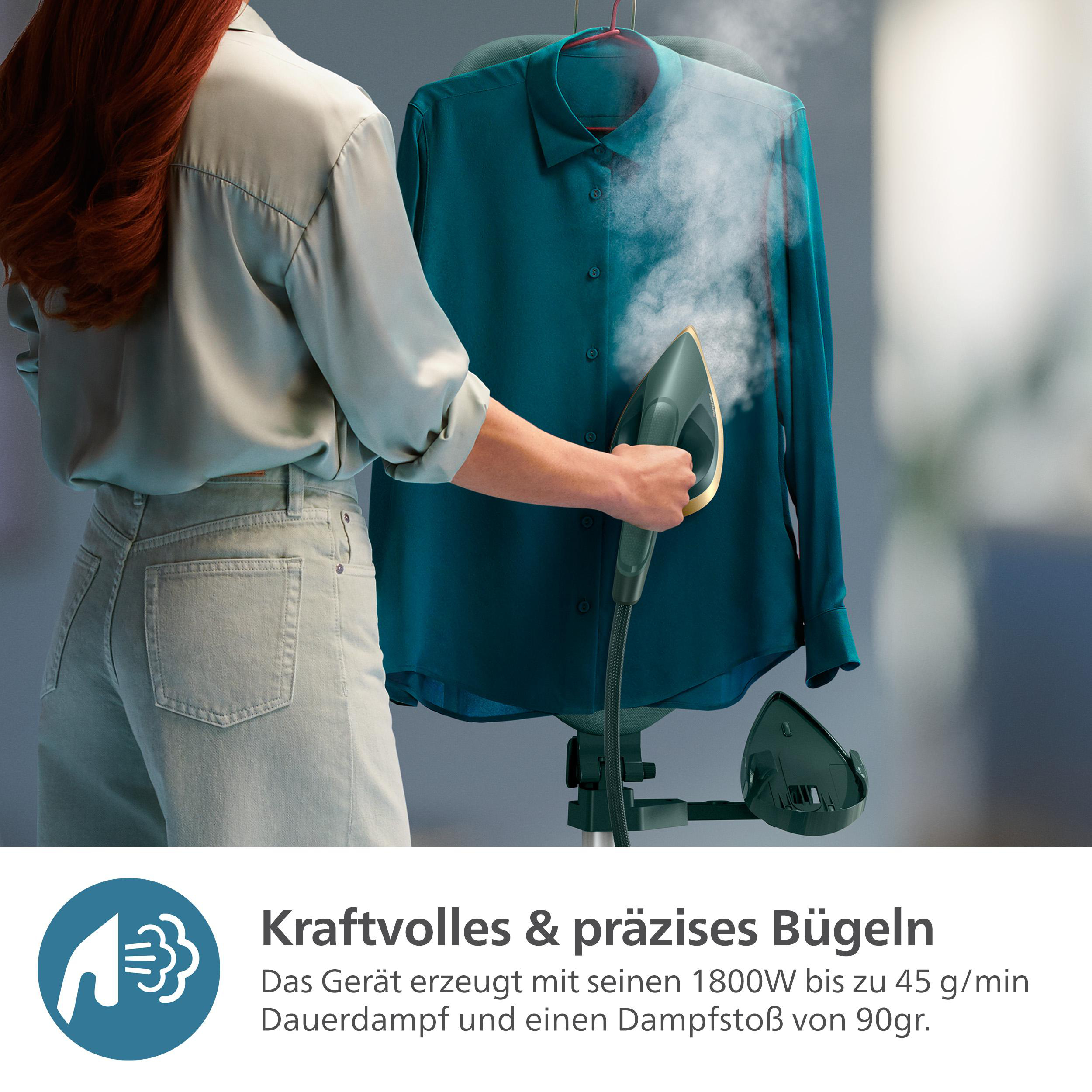 Eine Person, die ein türkisblaues Hemd mit einem grünen Handdampfer bedampft.