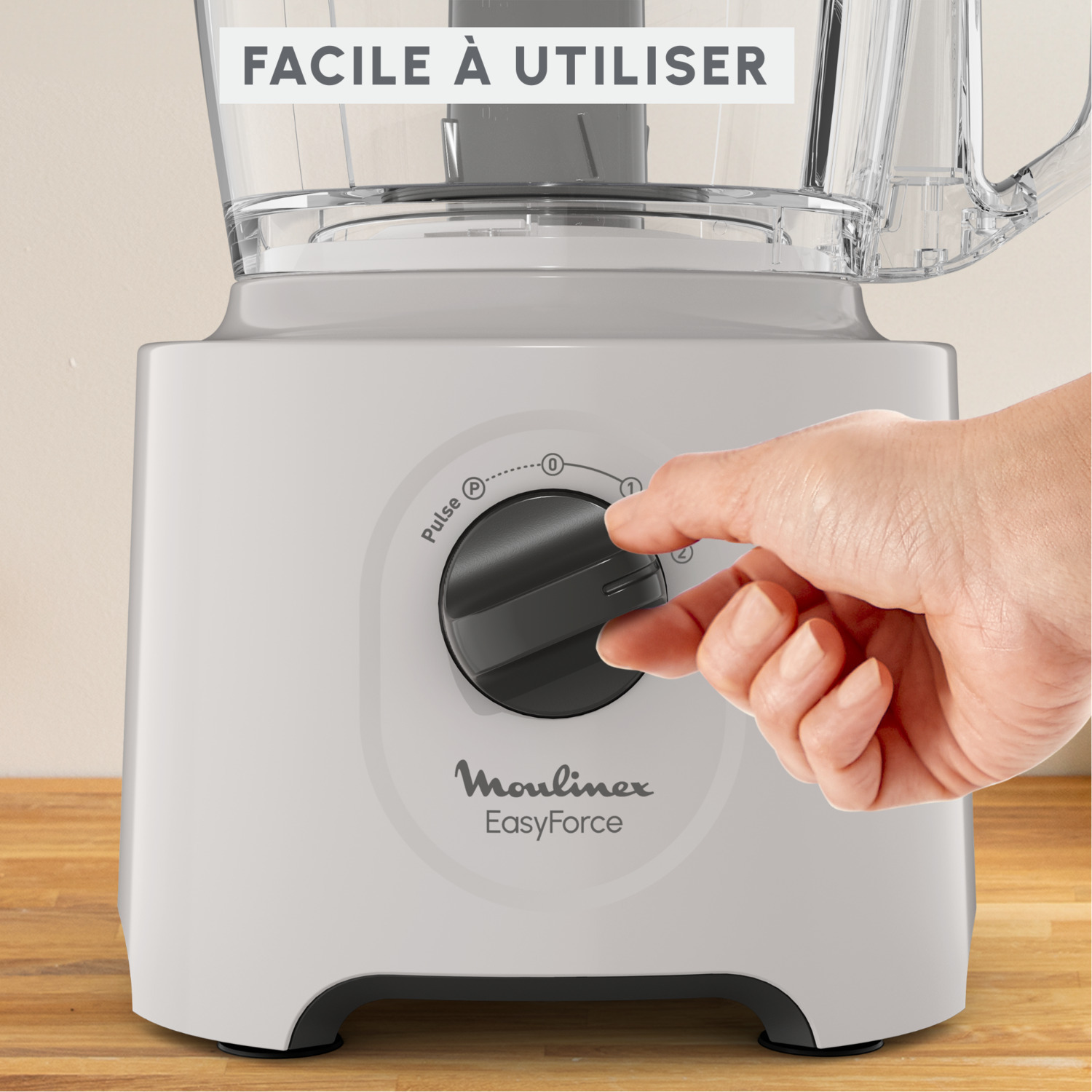 Une main tourne le cadran d'un robot culinaire blanc Moulinex EasyForce.