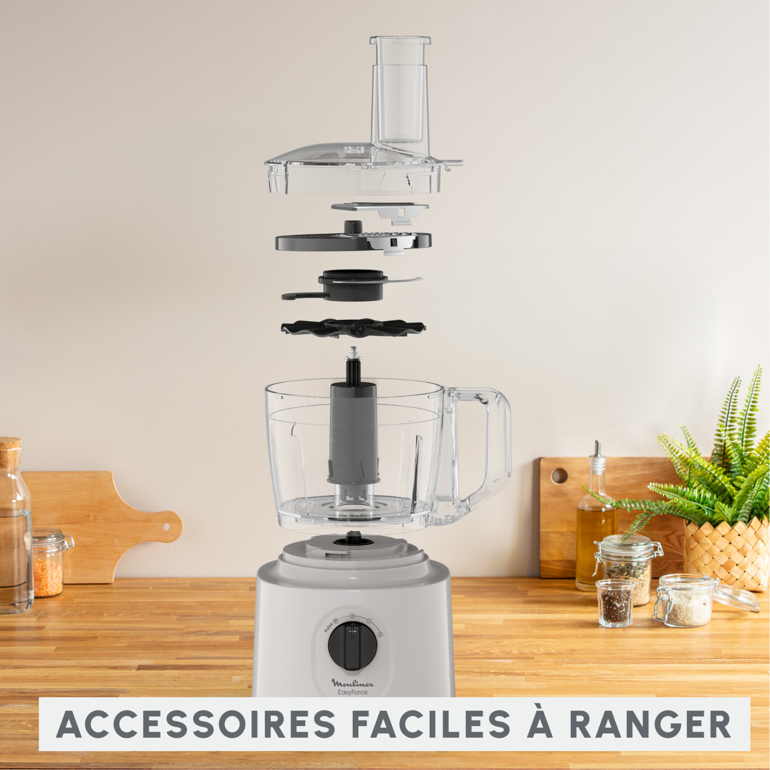 Vue éclatée d'un robot culinaire, pièces sur comptoir en bois, texte.
