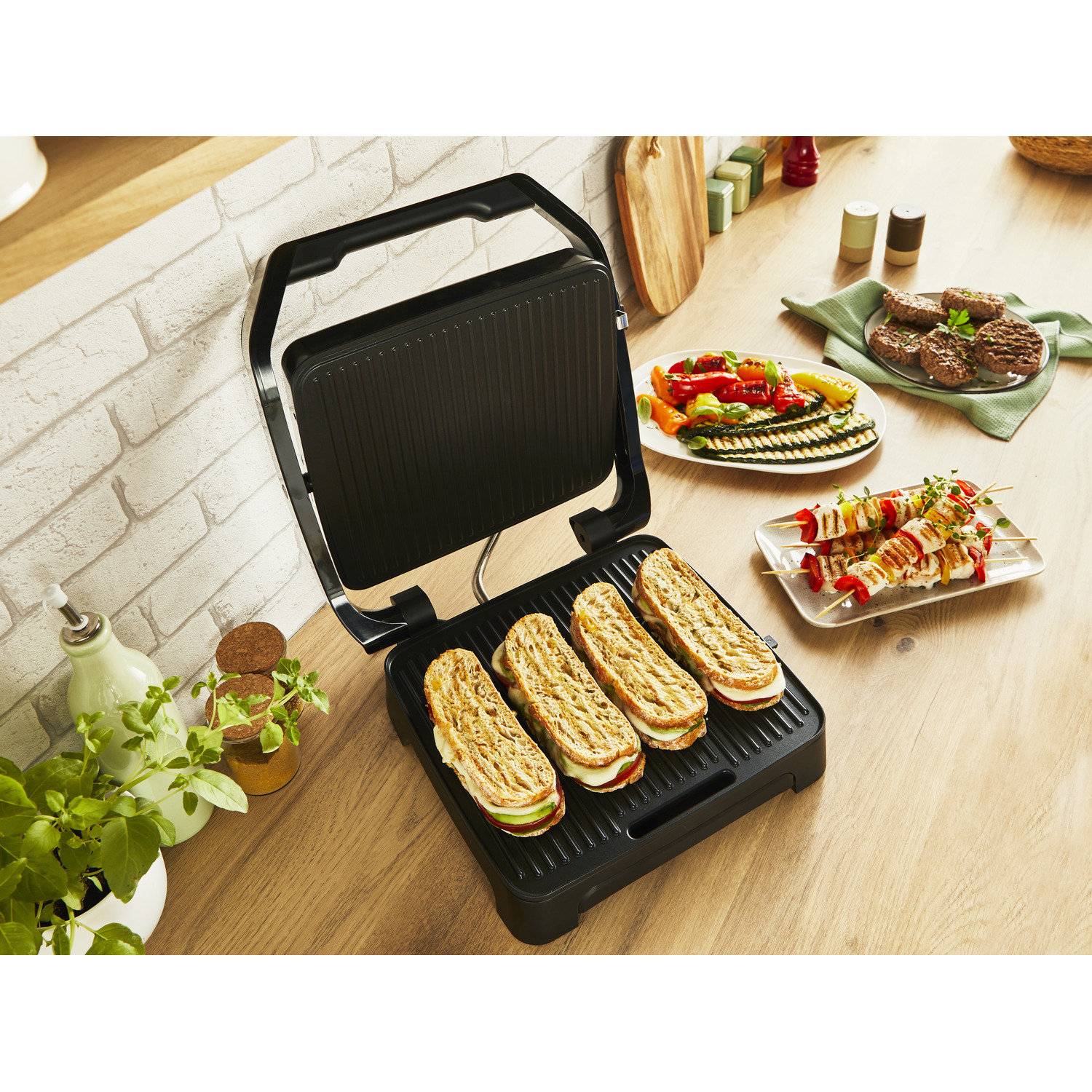Grill with sandwiches. Grilled food like vegetables and kebabs on a wooden table.