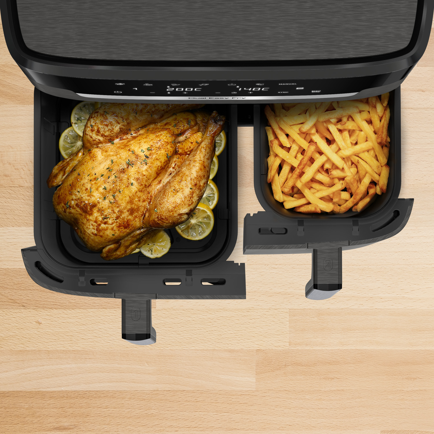 Een heteluchtfriteuse met een hele gebraden kip en friet in aparte bakken.