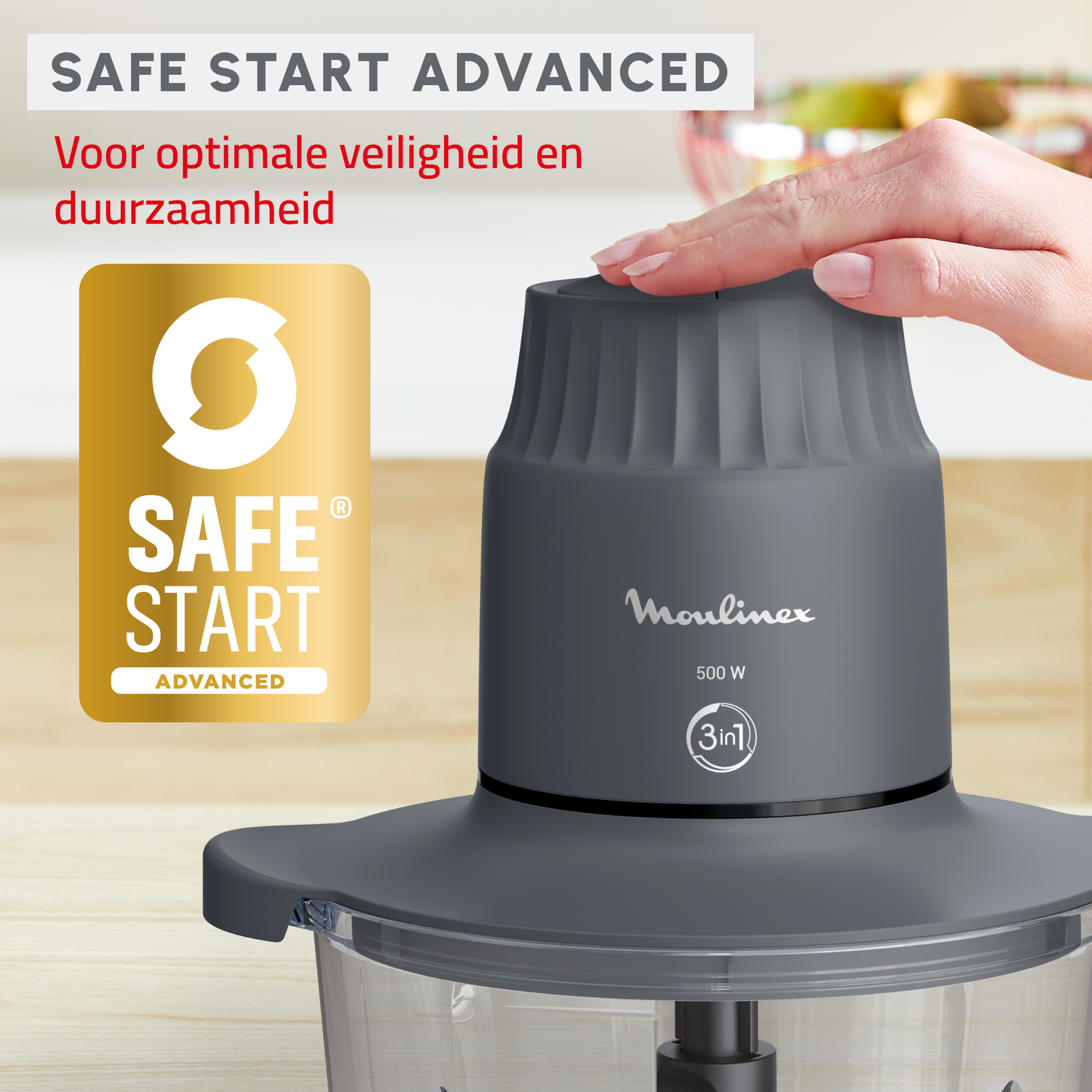 Grijze keukenmachine met een hand erop. De tekst "SAFE START ADVANCED" is zichtbaar.