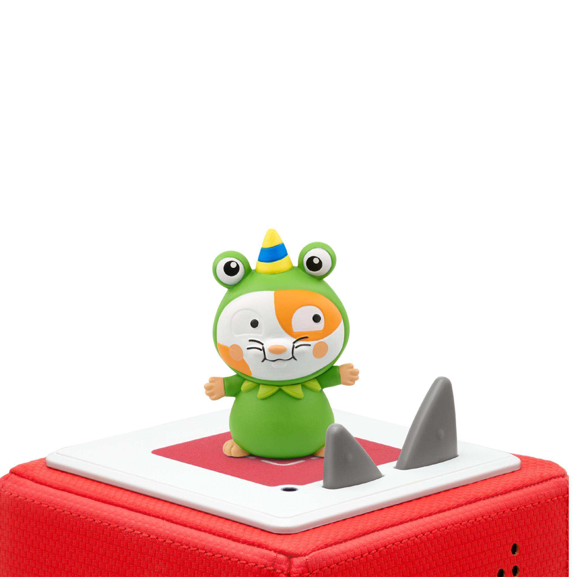 Ein Spielzeugfrosch in einem Kostüm mit Haifischflossen auf roter Basis.