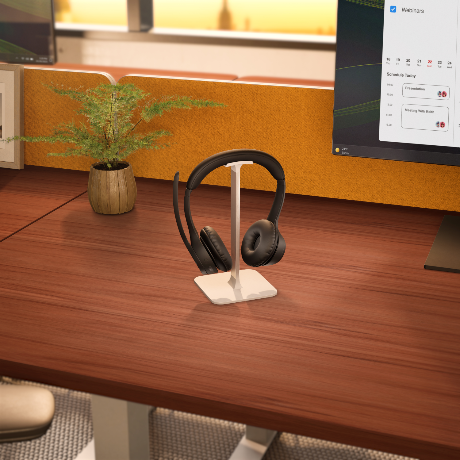 Kopfhörer auf einem Ständer auf einem Holztisch, mit Computer und Pflanze im Hintergrund.