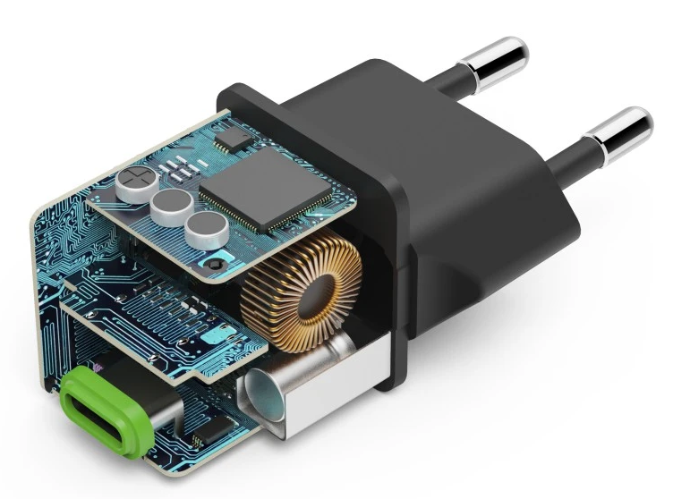 Egy fekete töltő metszeti képe, elektronikus alkatrészekkel és zöld USB-C porttal.
