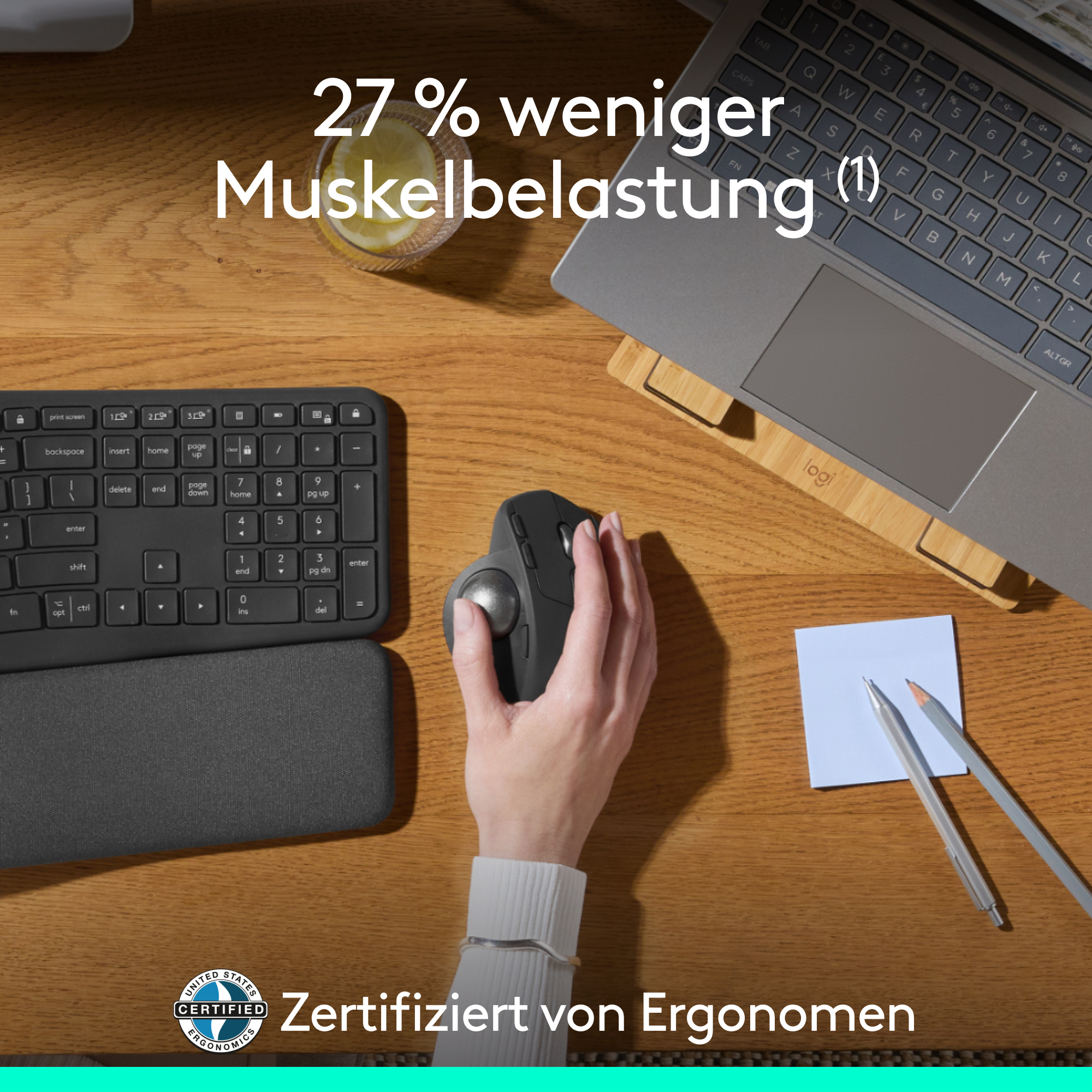 Person nutzt eine schwarze Maus mit Tastatur, Laptop und Notizblock auf Holzschreibtisch.