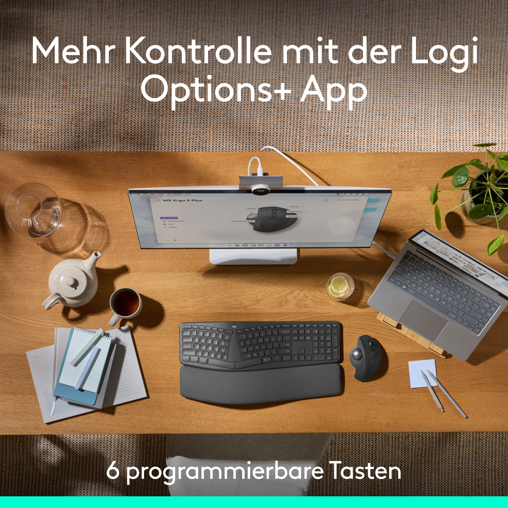 Eine Draufsicht auf einen Schreibtisch, einschließlich Monitor, Tastatur, Maus und Tee.