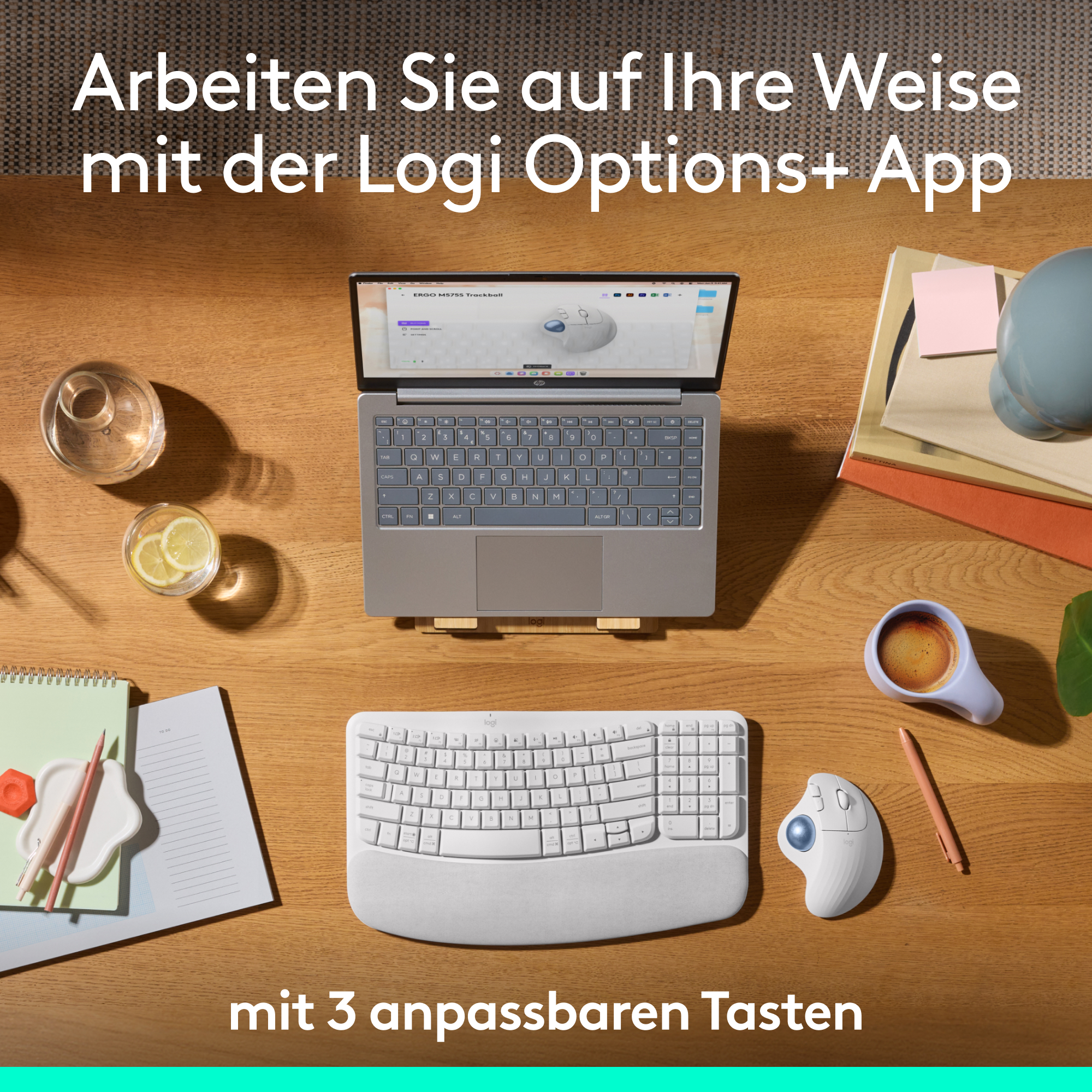 Ein Tisch mit Laptop, Tastatur, Maus, Getränken und Schreibwaren.