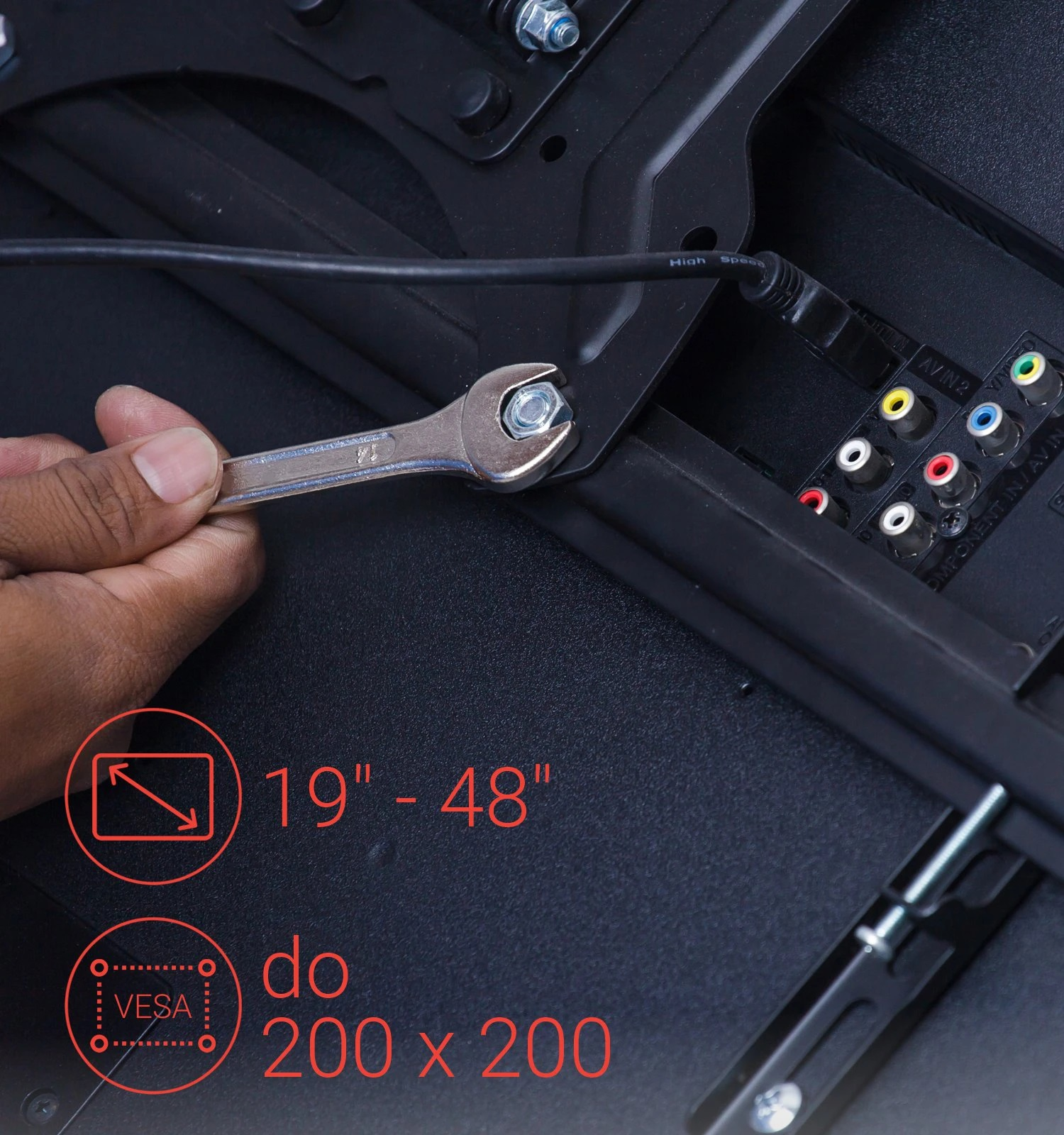 Ręka używająca klucza do dokręcania śruby z tyłu telewizora, z informacjami VESA i rozmiarem.